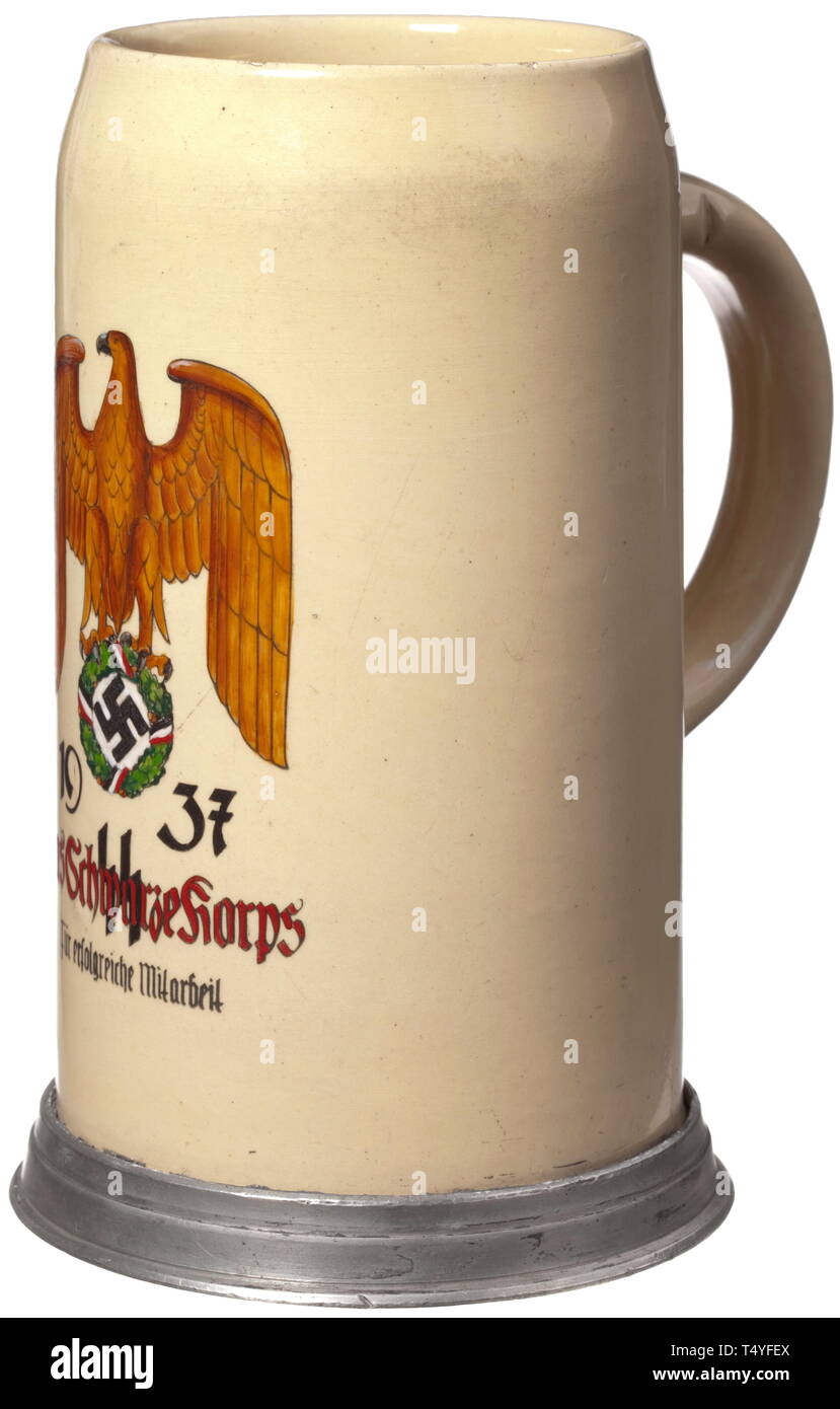 A beer stein 'The Black Corps'. Earthenware beer stein of 1-litre-capacity with tin mountings, the viewing side with an enamelled national eagle and '1937 Das Schwarze Korps -SS- für erfolgreiche Mitarbeit' (1937 The Black Corps -SS- for successful cooperation). Usage marks. Height 19 cm. historic, historical, 20th century, 1930s, 1940s, Waffen-SS, armed division of the SS, armed service, armed services, NS, National Socialism, Nazism, Third Reich, German Reich, Germany, military, militaria, utensil, piece of equipment, utensils, object, objects, stills, clipping, clippings, Editorial-Use-Only Stock Photo