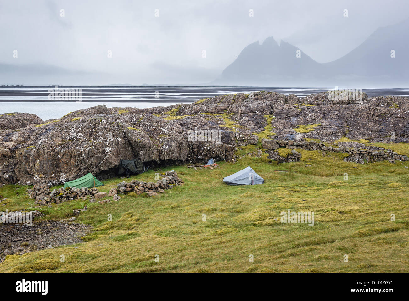 Tents among rocks in southeast part of Iceland, Brunnhorn mountain on background Stock Photo