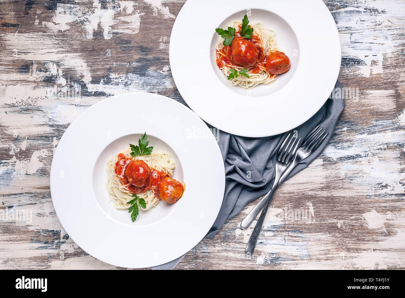 Top view meatballs in tomato sauce with basil and cardamom with spaghetti on large white plates Stock Photo