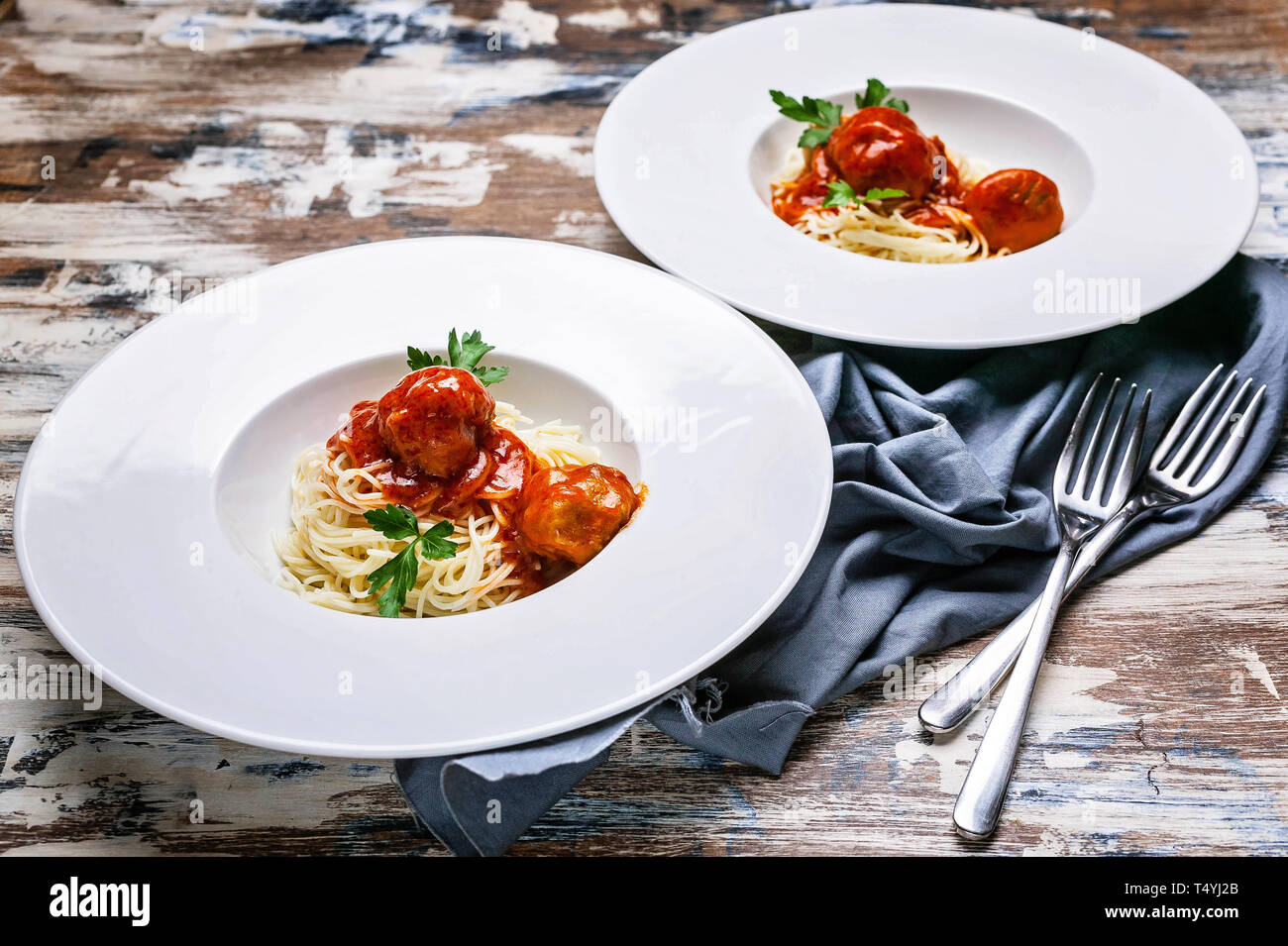 Meatballs in tomato sauce with basil and cardamom with spaghetti on large white plates Stock Photo