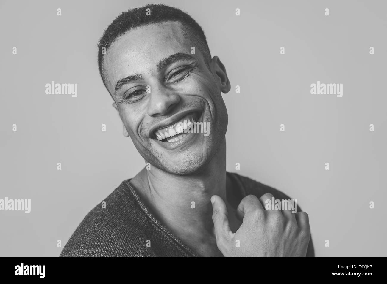 Portrait of happy african american man having fun and joy smiling at the camera and looking to something that makes him lough. In Human emotions facia Stock Photo
