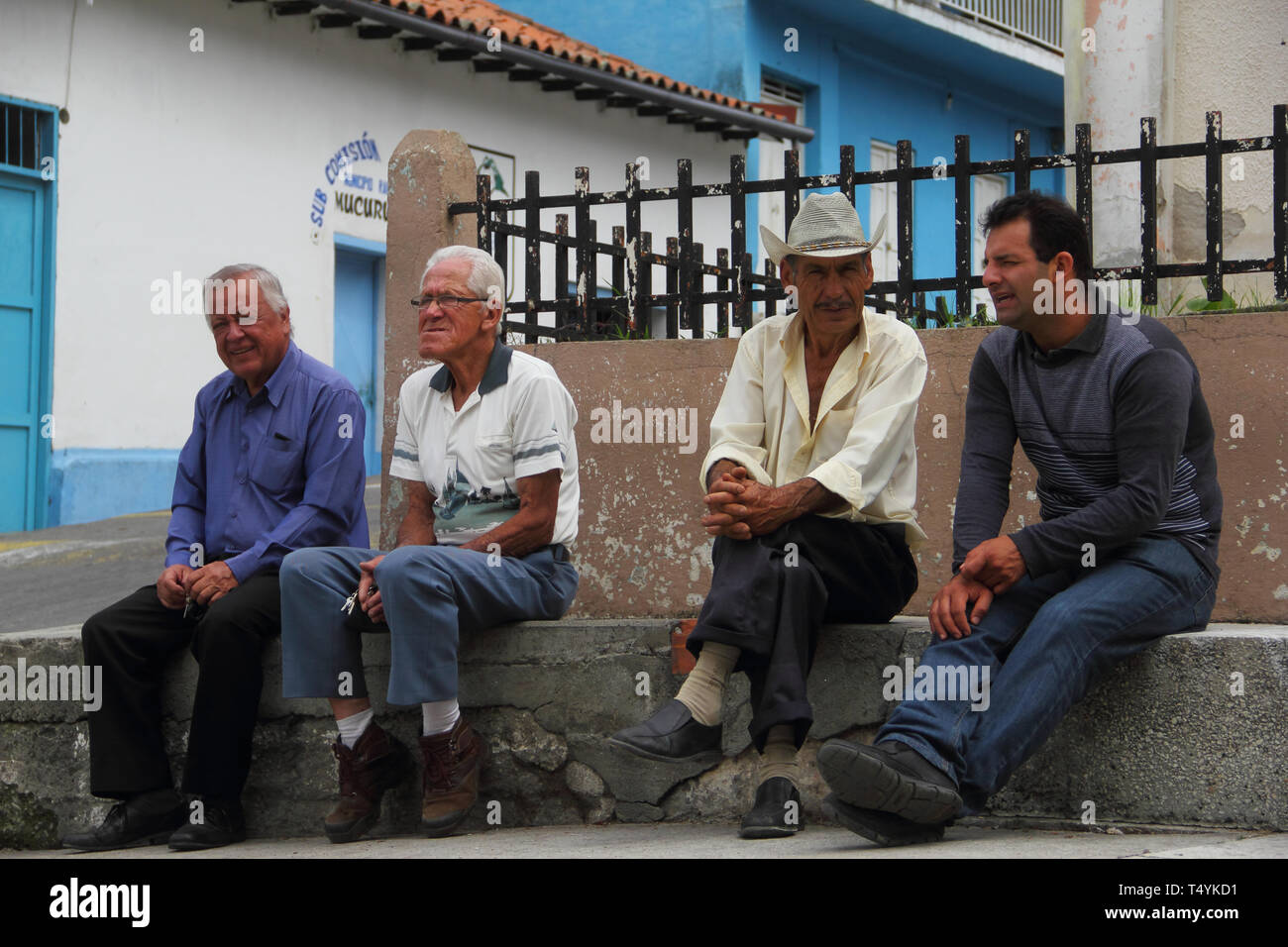 Merida, Venezuela - April 7, 2017: Local men in casual wear sits and discussing with each other in outdoors of town area. Stock Photo