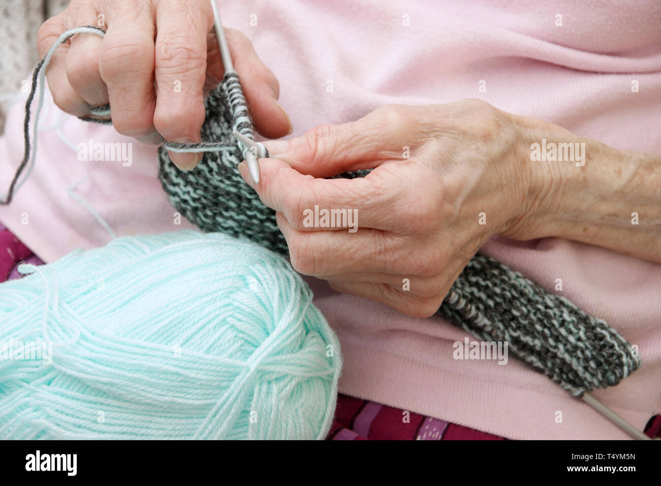 Elderly woman knitting a garment Stock Photo