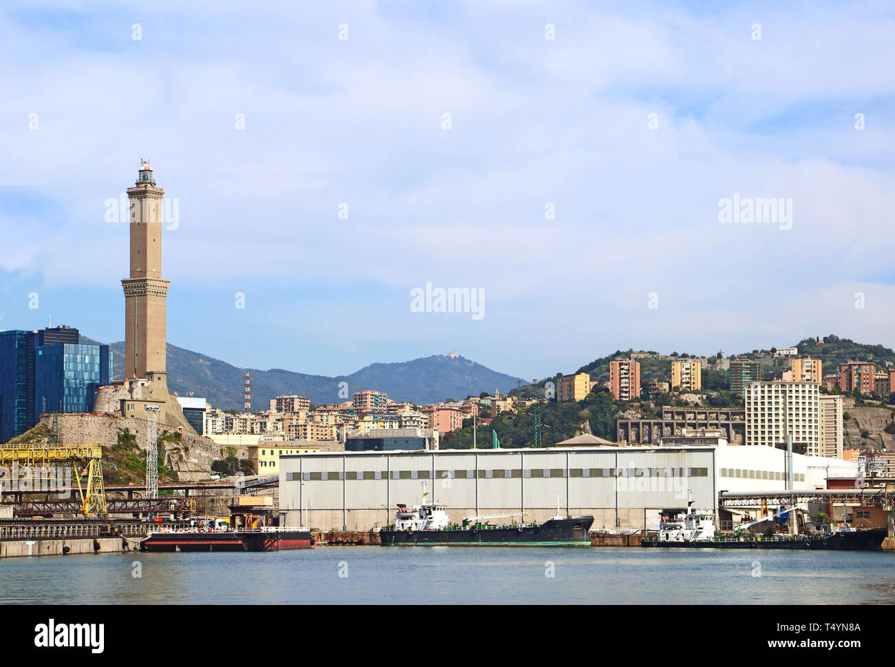 Genoa harbor with the container port and the lighthouse called La Lanterna  built around 1128, it is one of the world oldest and represents the symbol Stock Photo