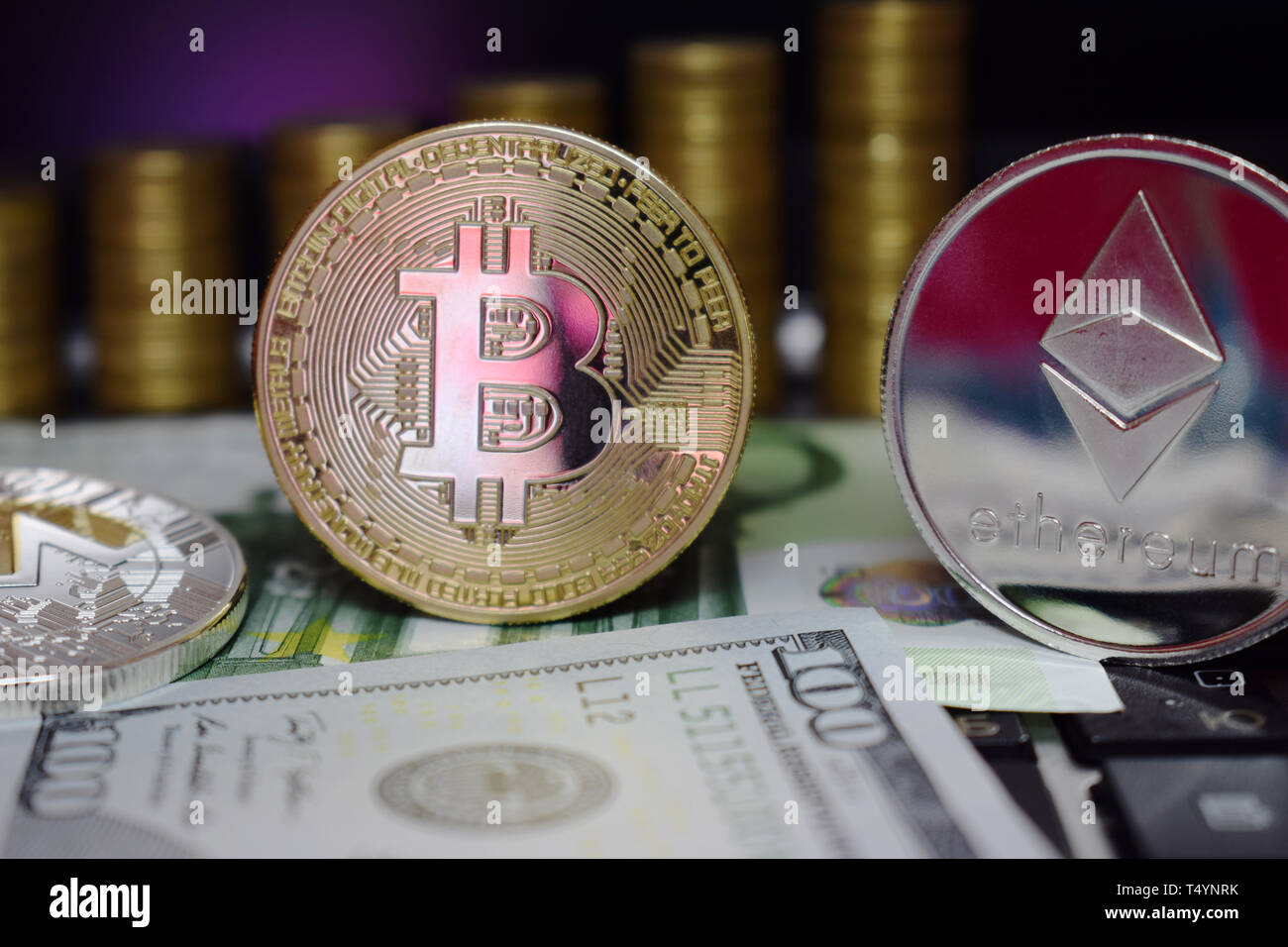 Physical coin Golden Bitcoin BTC and Etherum ETH on banknotes Euro and Us Dollar. Background of gold coins. Virtual money. Stock Photo