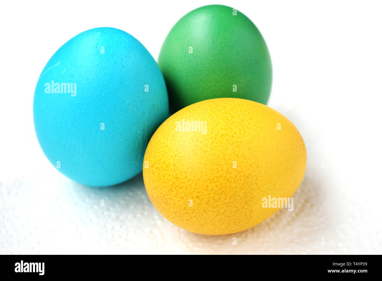 Three eggs are green, blue and yellow. Easter eggs on a white background Stock Photo