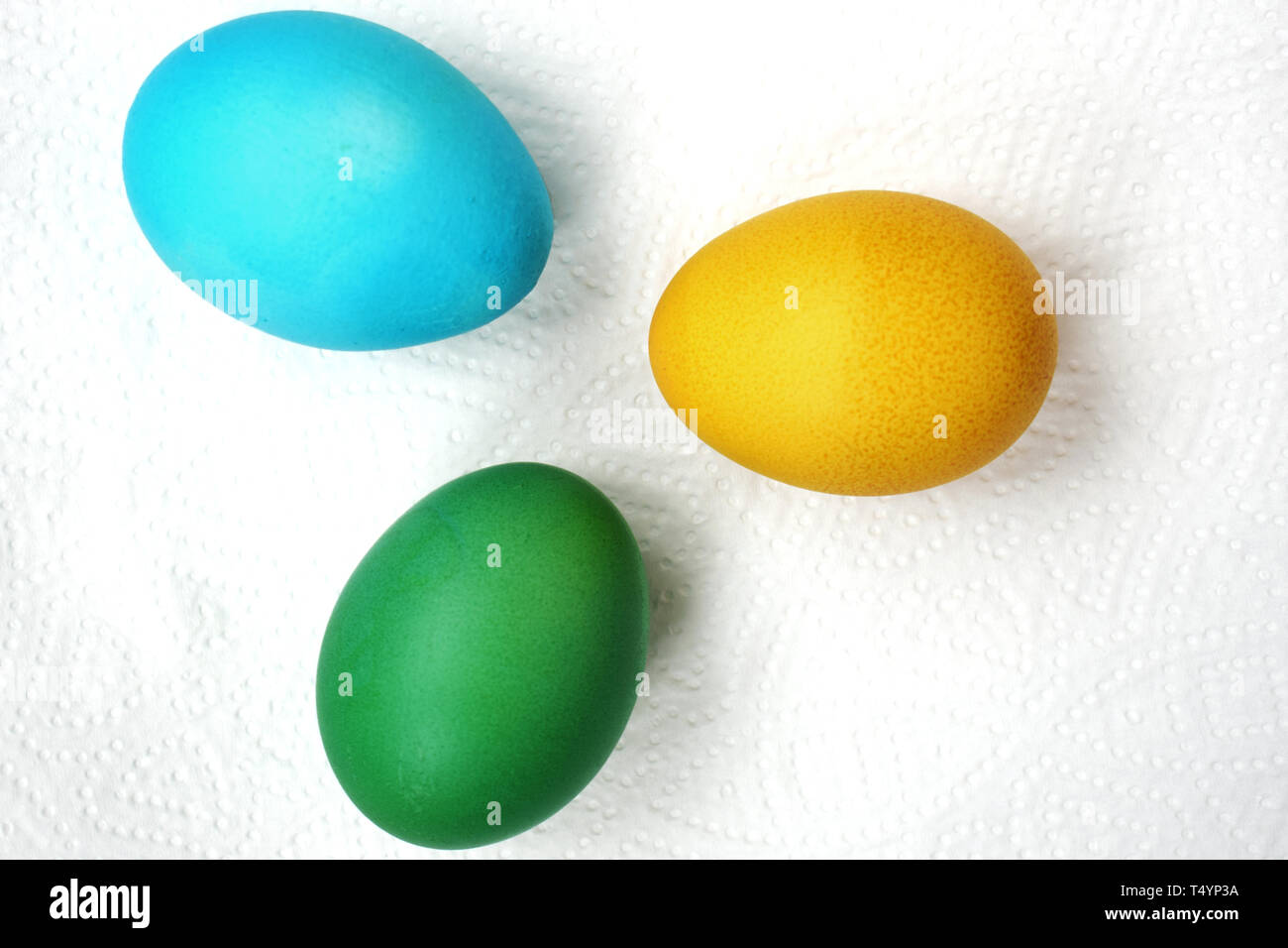 Three eggs are green, blue and yellow. Easter eggs on a white background Stock Photo