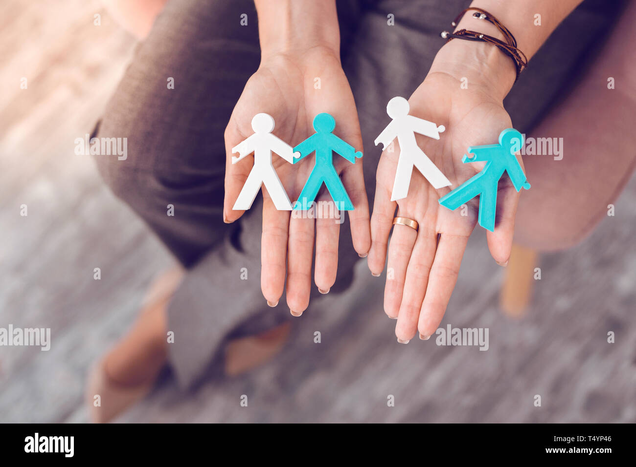 Close-up photo of human stick figures being placed on palms. Stock Photo