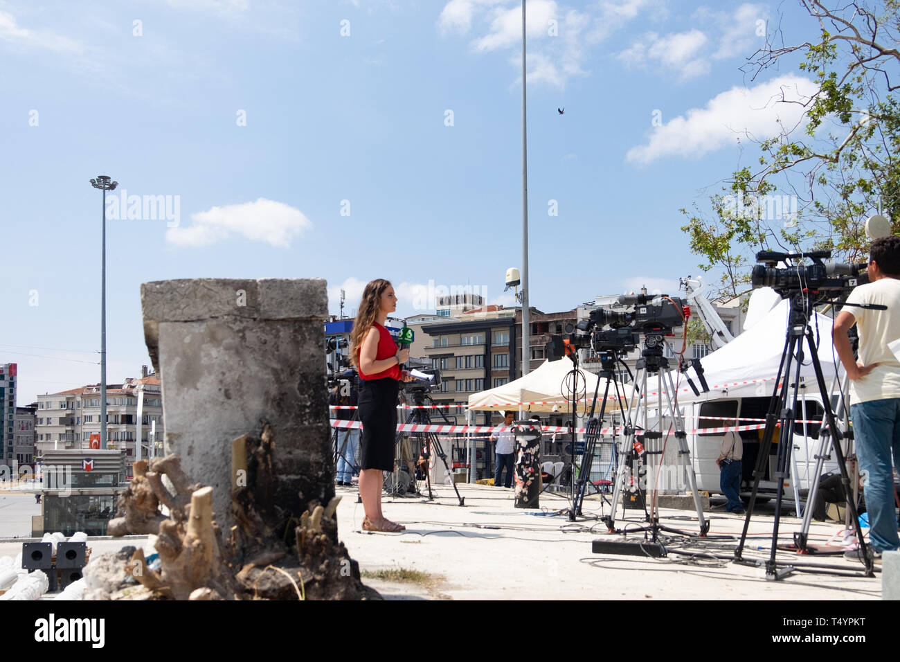 Istanbul, Turkey - June 17, 2016: News reporter reporting in front a camera for a live telecast at Taksim square in Istanbul. Stock Photo