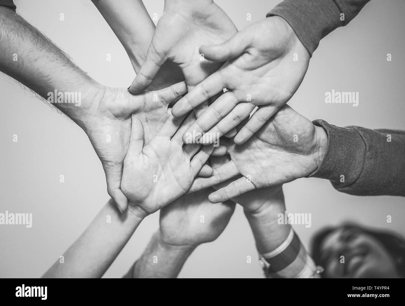 Close up of young teamwork putting their hands together for a new collaboration - Cheerful friends motivated on a plan Stock Photo