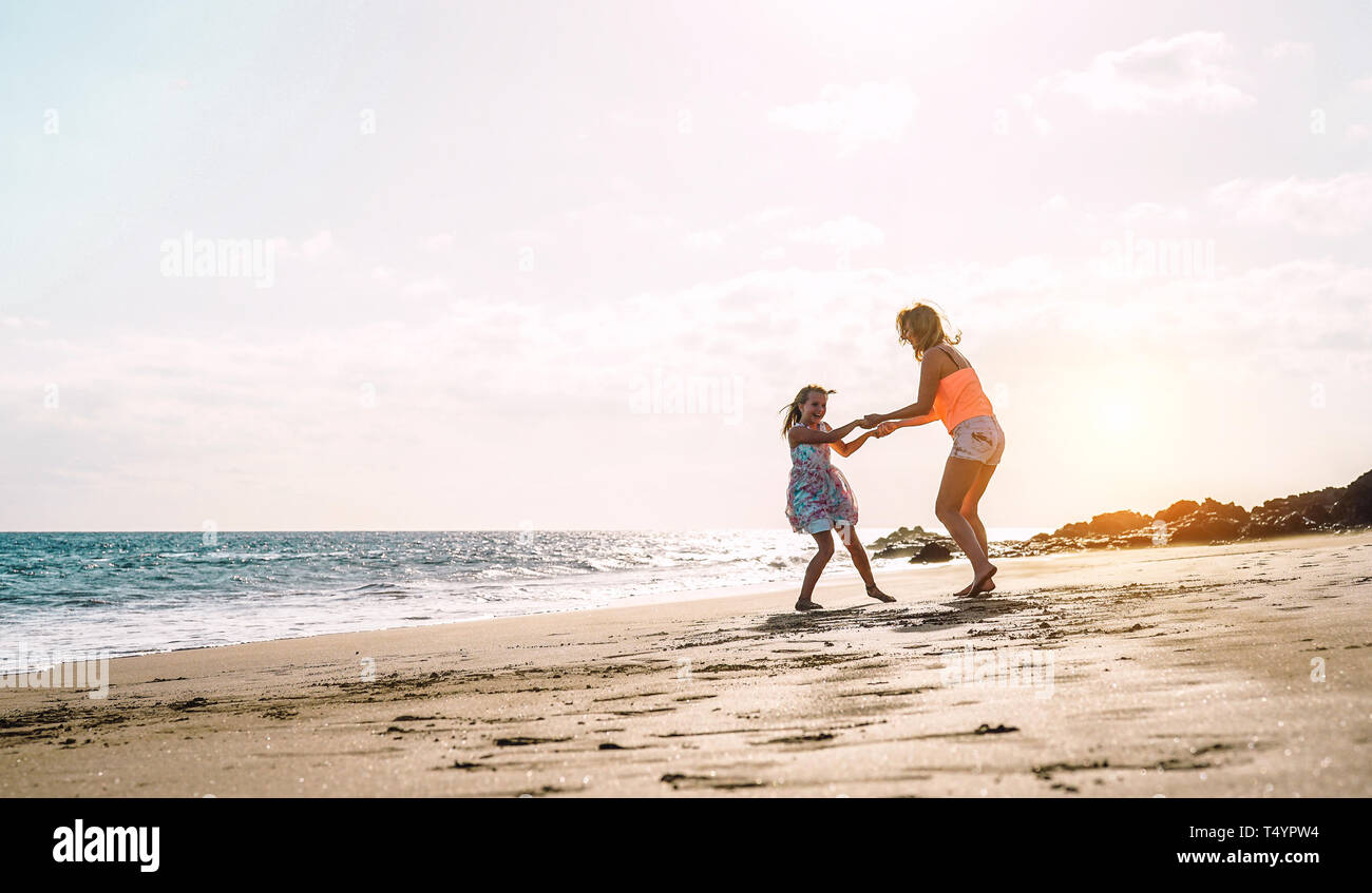 Happy loving family mother and daughter having fun on the beach at