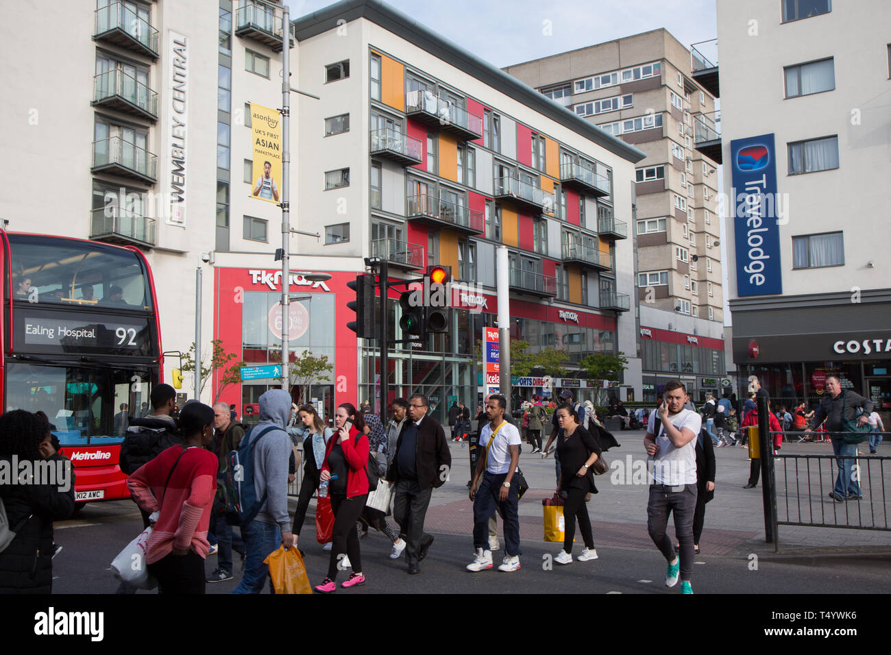 Pedestrians crossing High Road, Wembley, in front of a modern shopping