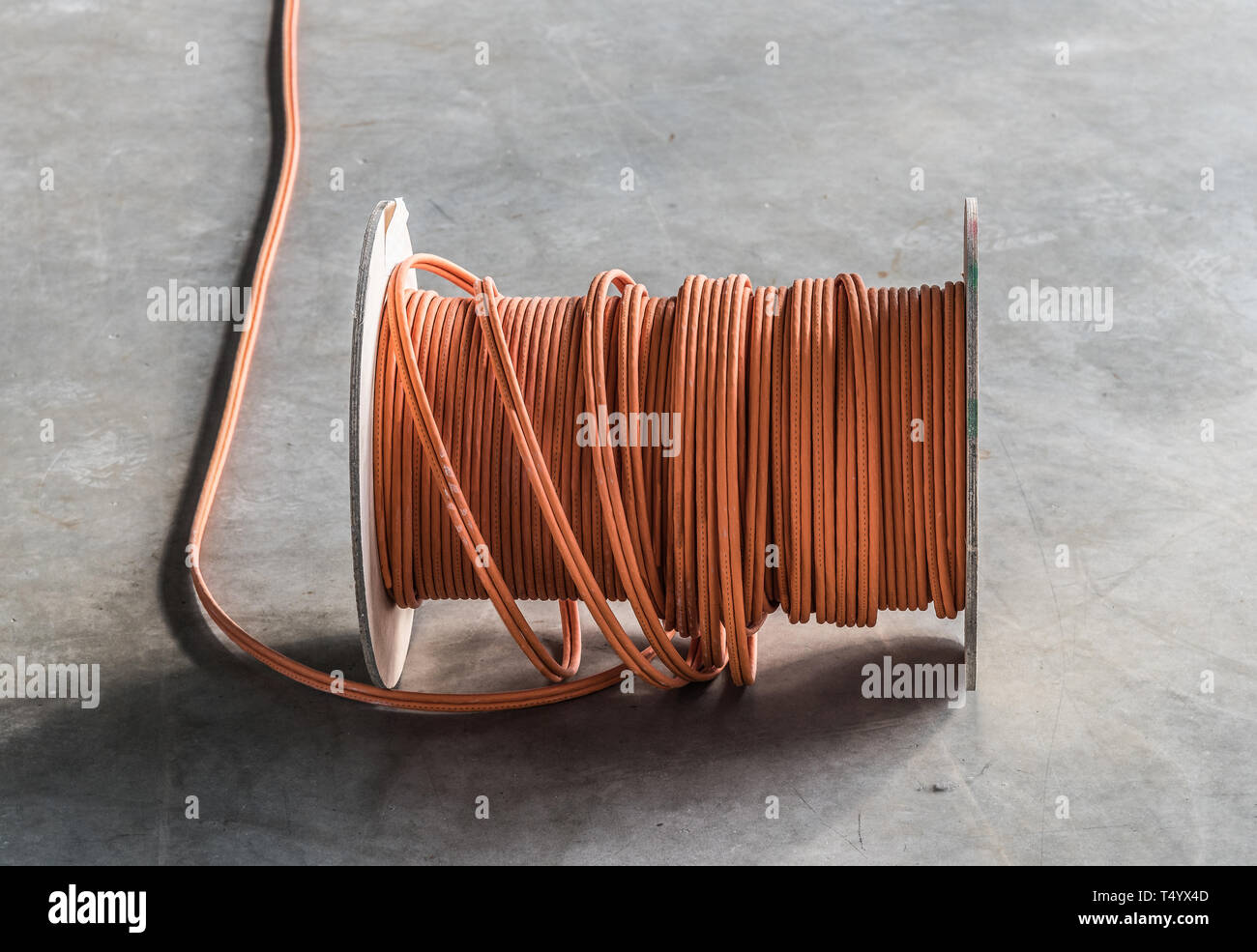 large roll of communications cable on concrete floor at construction site Stock Photo