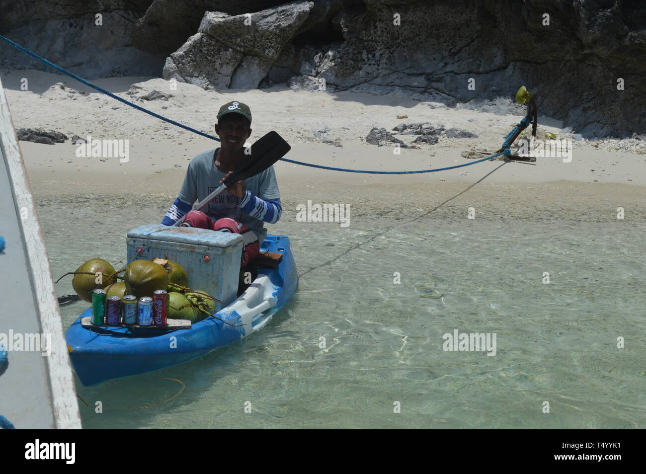 The coconut vendor is roaming around in the boat to offer his product to the passenger. Stock Photo