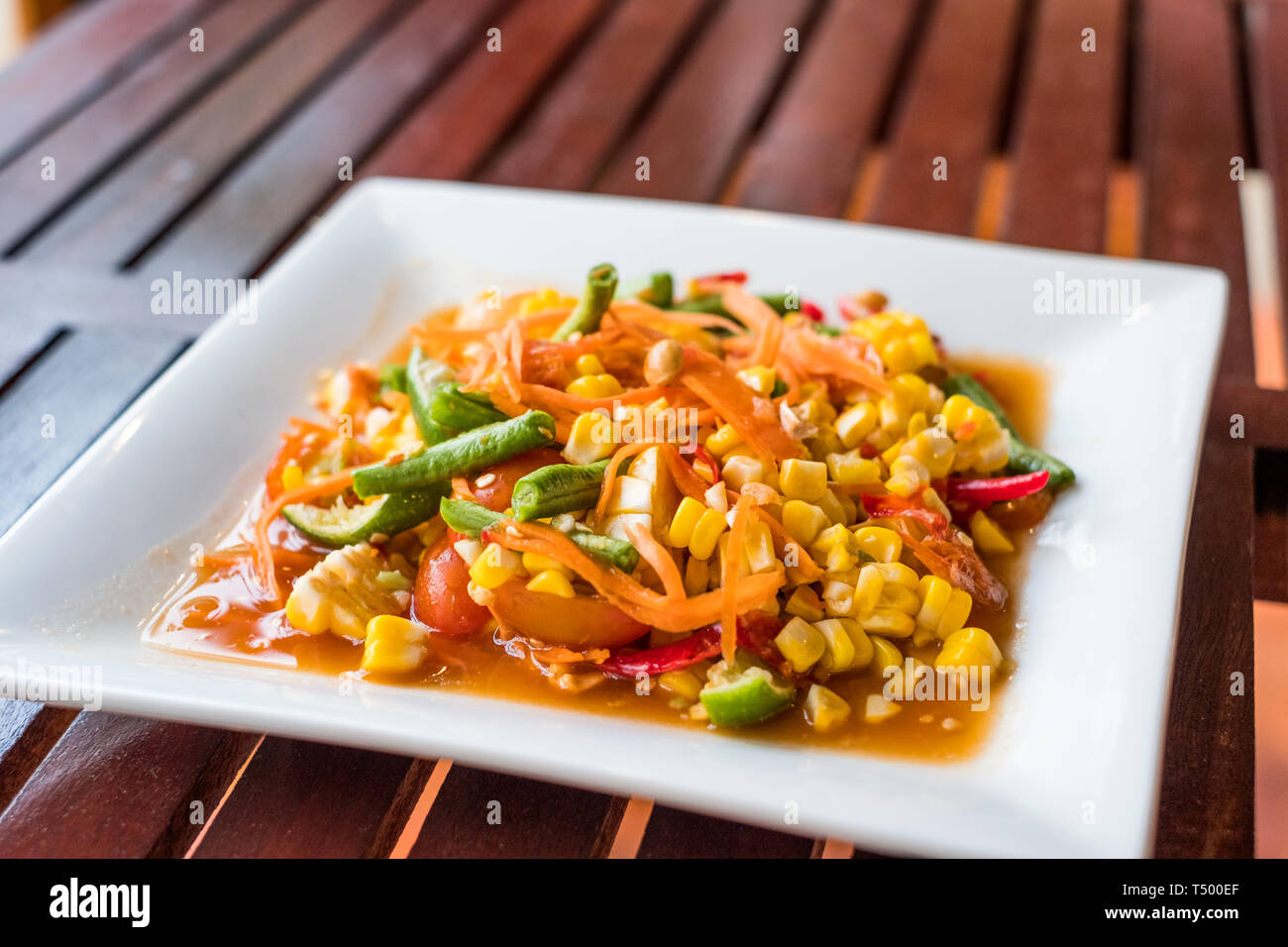 Corn seeds with fruits and vegetables sour spicy in white plate Stock Photo