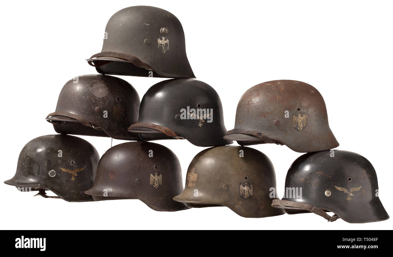 Eight steel helmets - all service branches, M 35/40/42. Luftwaffe M 35 and navy M 40 each with a single decal, army M 40 with two decals, army M 42 with decal and four further helmets. The helmets in varying states of preservation and sizes, some marked, re-painted and assembled from modern as well as old parts, resp. with national emblems, inner liners and chin straps replaced. historic, historical, 20th century, 1940s, Wehrmacht, armed forces, army, NS, National Socialism, Nazism, Third Reich, German Reich, Germany, Editorial-Use-Only Stock Photo