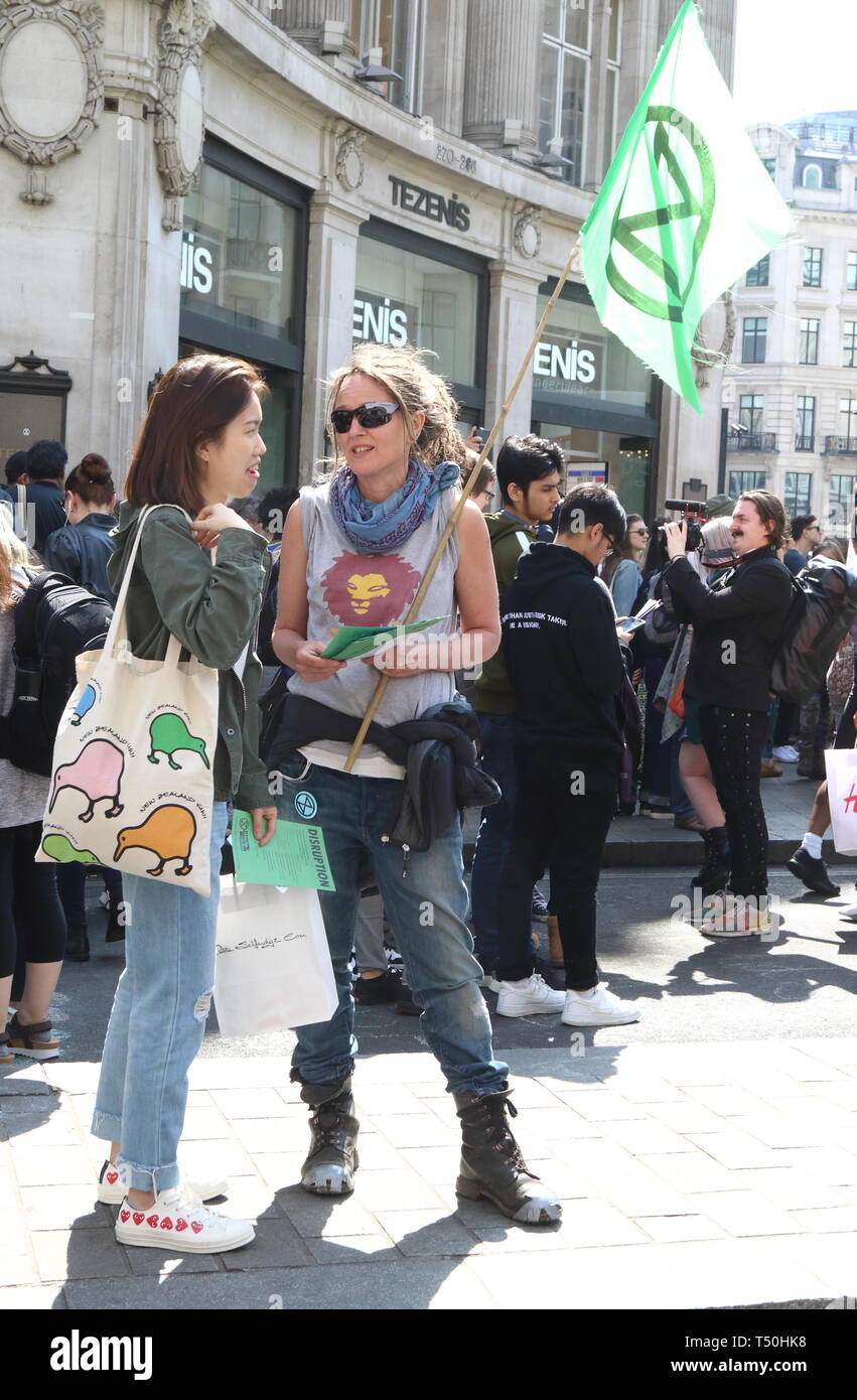 Activist seen with leaflets during the demonstration. Environmental activists from Extinction Rebellion movement occupy London's Oxford Circus for a 5th day. Activists parked a pink boat in the middle of the busy Oxford Circus road junction blocking the streets and causing traffic chaos. Stock Photo