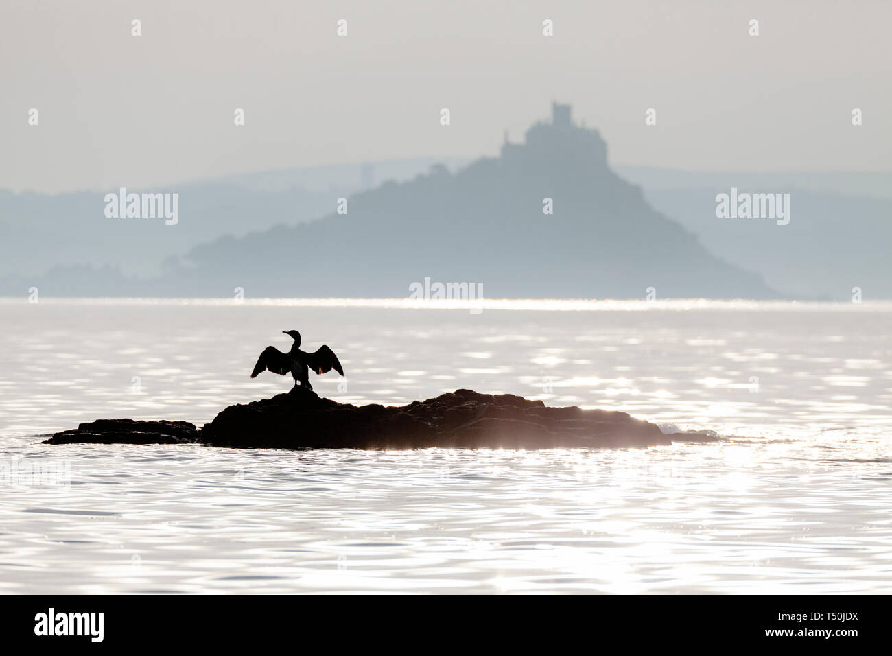 Penzance, Cornwall. 20th April 2019. UK Weather: A hazy sunrise at St Michael's Mount is the forerunner to another hot Easter day.  Credit: Mike Newman/Alamy Live News. Stock Photo
