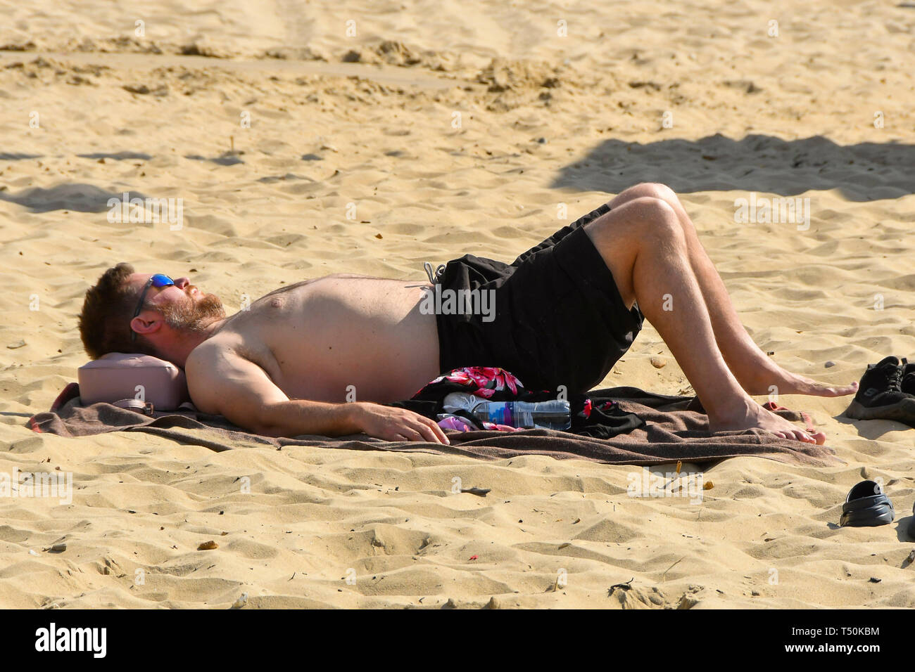 Bournemouth, Dorset, UK. 20th Apr, 2019. UK Weather. A sunbather topping up his tan on Boscombe Beach at Bournemouth in Dorset on another clear hot sunny day during the Easter weekend. Picture Credit: Graham Hunt/Alamy Live News Stock Photo