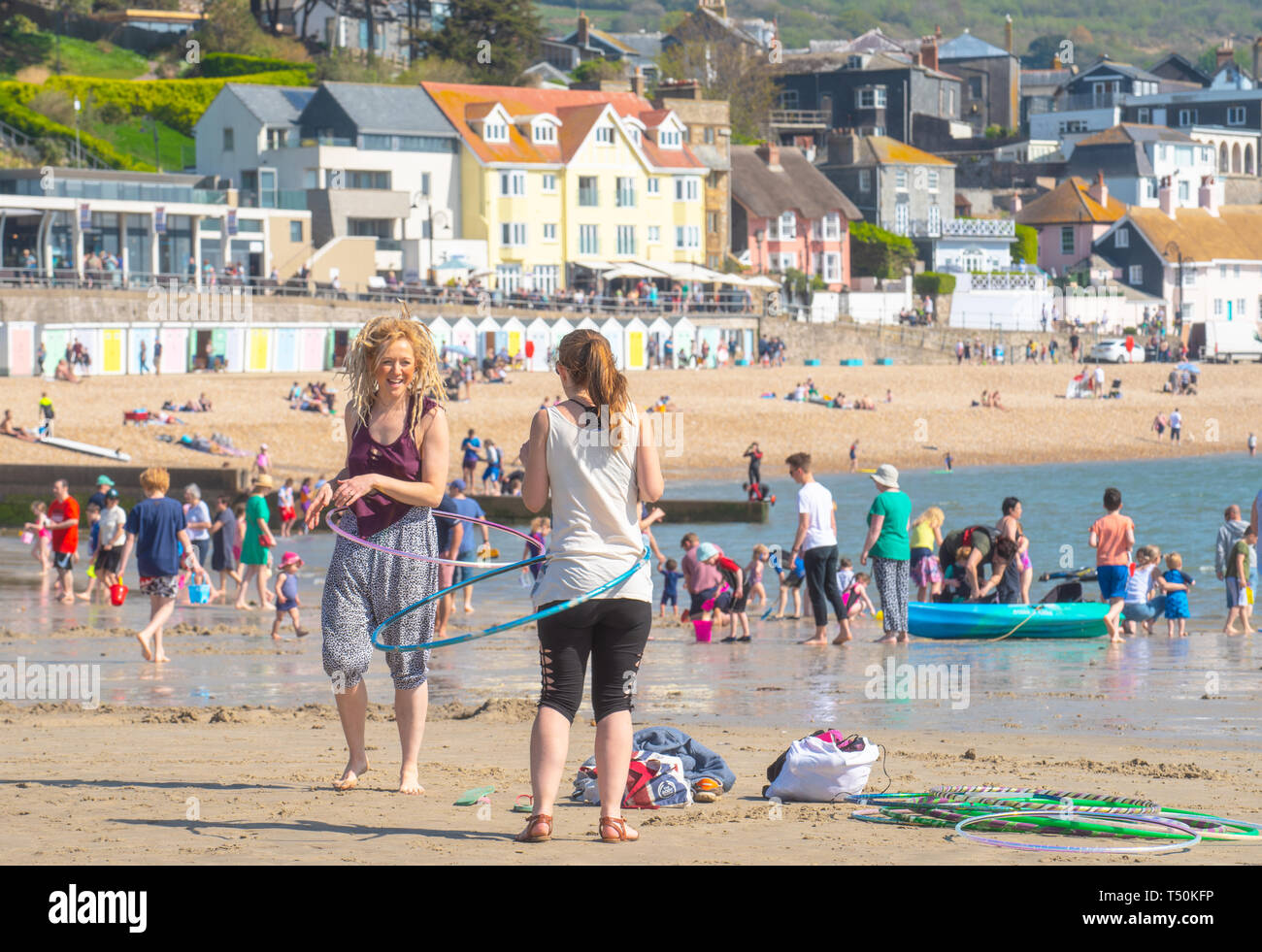 Lyme Regis, Dorset, UK. 20th April 2019. UK Weather: Holiday makers and beachgoers pack the pretty beach at the seaside resort of Lyme Regis to bask in sizzling hot Easter Saturday sunshine on the hottest day of the year so far.  Sunbathers enjoy bright blue skies as they soak up the sun in record breaking Easter Bank Holiday temperatures and the hottest Easter weekend for 70 years. The town's main beach is packed by 10.30 am. Credit: Celia McMahon/Alamy Live News. Stock Photo
