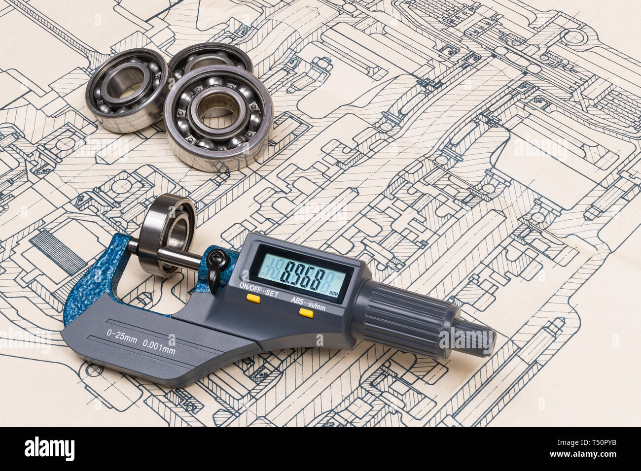 Micrometer screw gauge. Ball bearings. Drawing on background. Accurate measuring tool. Digital display. Round metal parts group. Engineering design. Stock Photo