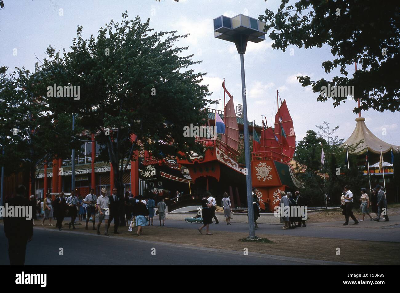 People walking on a sidewalk near mock Chinese junks that formed part of the Hong Kong Pavilion during the New York World's Fair, Flushing Meadows Park, Queens, NY, June 1964. () Stock Photo