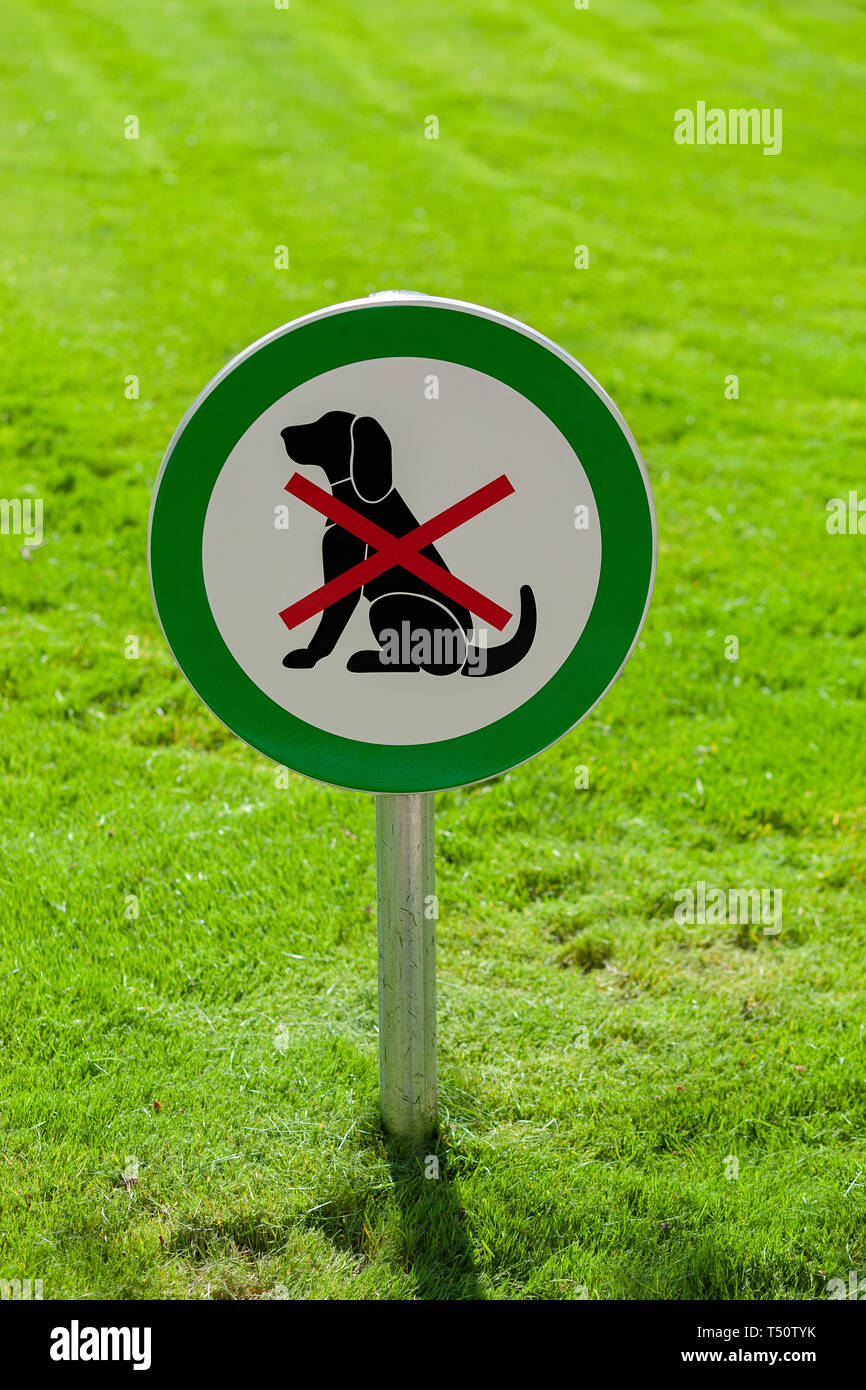 Picture of Freshly cut green grass with round sign forbidding dogs, no dogs ...