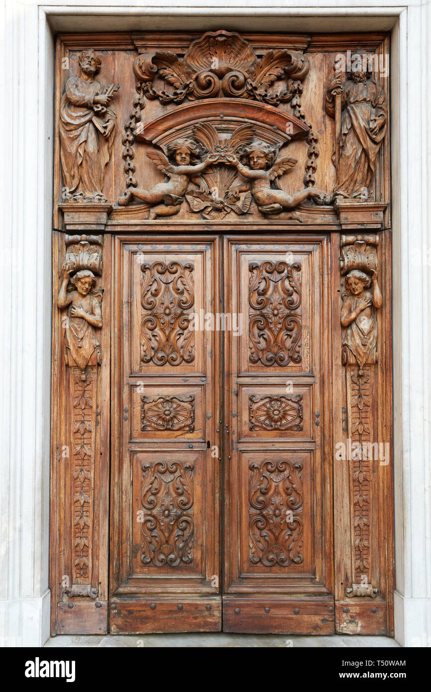 Ancient wooden church portal with sculpures and decorations in Piedmont, Italy Stock Photo
