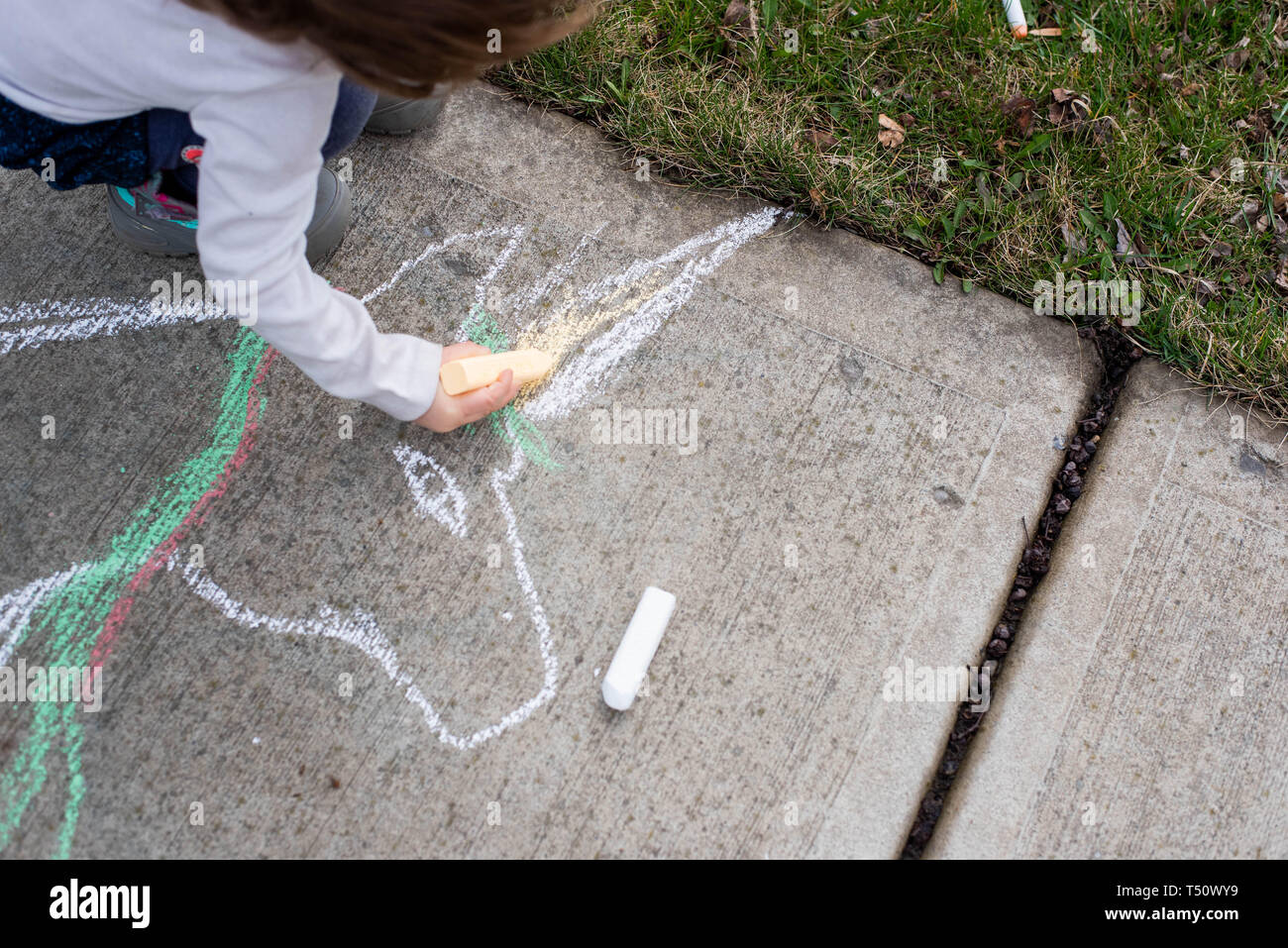 Little girl drawing on a sidewalk with sidewalk chalk Stock Photo - Alamy