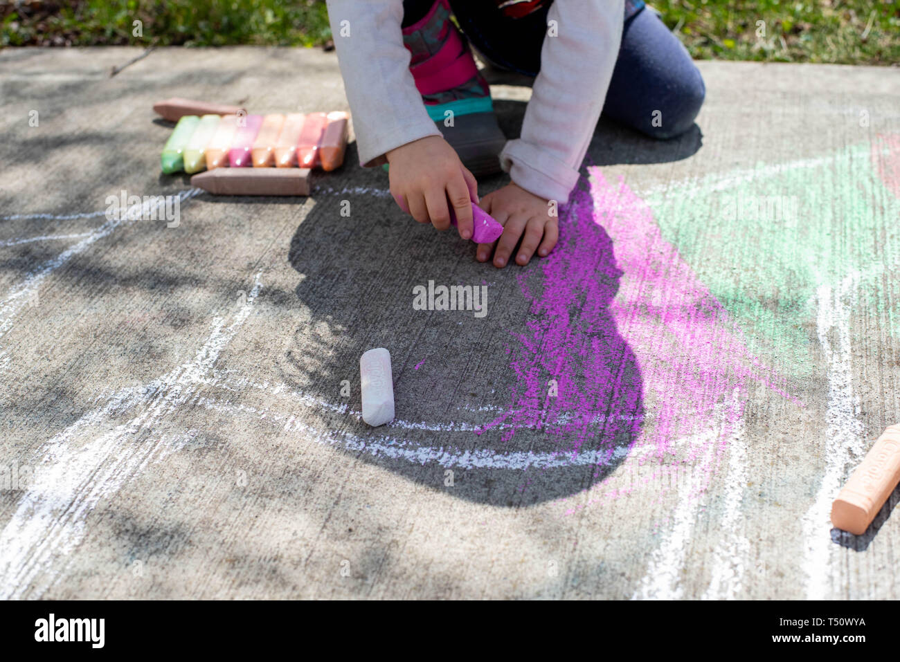 Little girl drawing on a sidewalk with sidewalk chalk Stock Photo - Alamy
