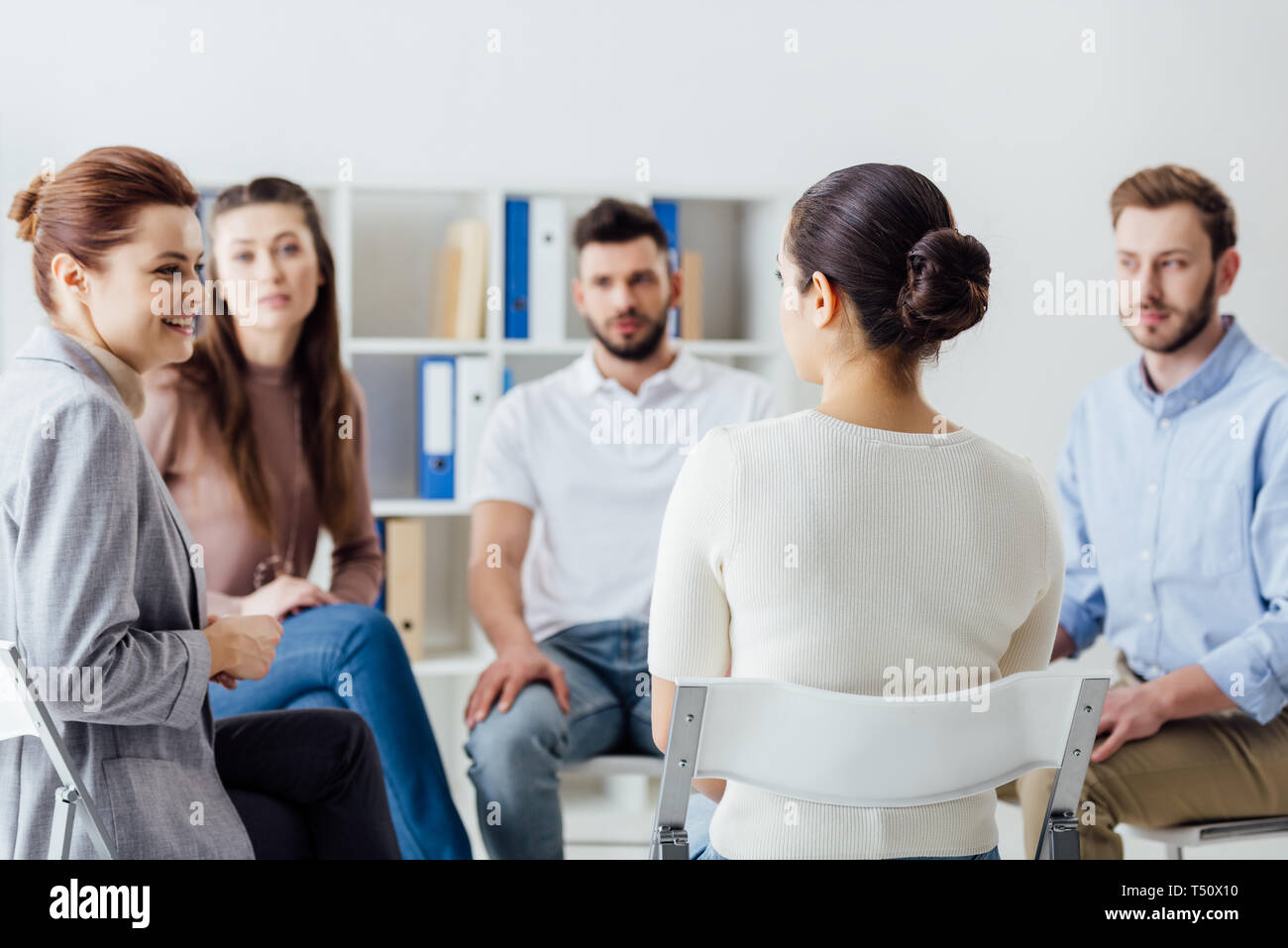group of people sitting in circle on chairs during support group