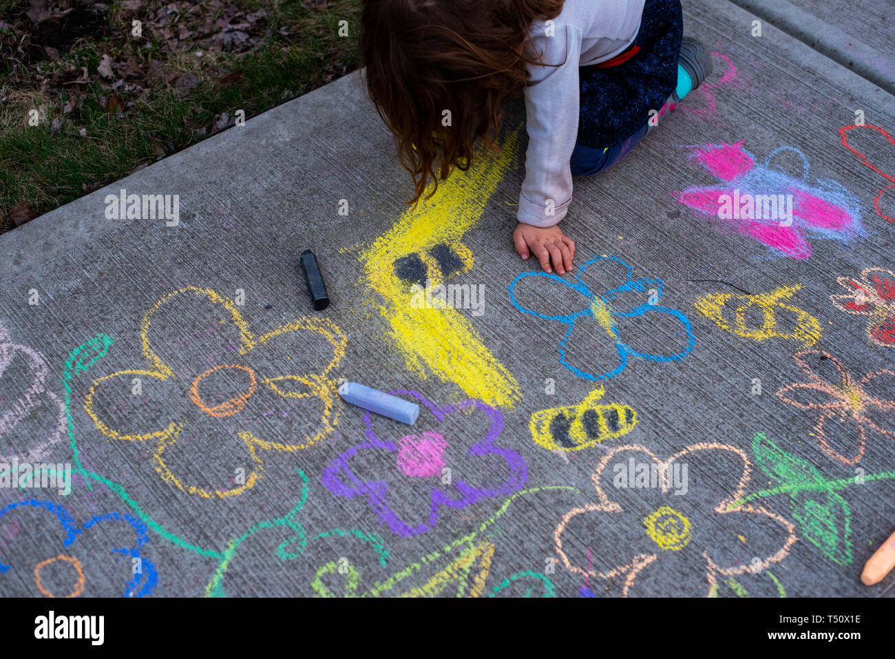 A Young Girl Drawing With Sidewalk Chalk On The Sidewalk In Summer Stock Photo Alamy