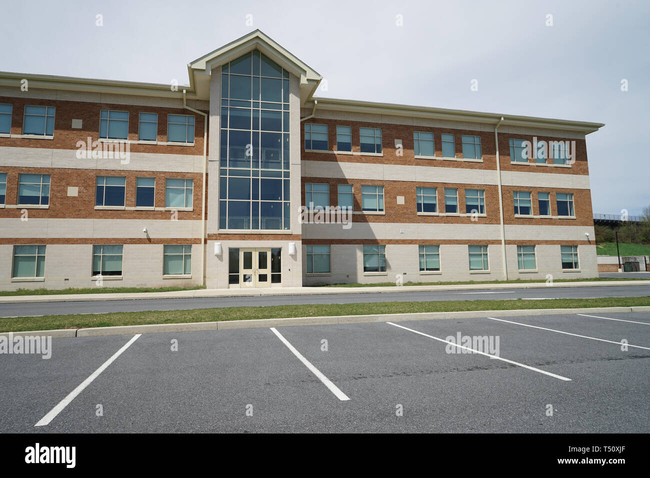 Exterior view of a large modern school.  There are double doors and many windows.  This is Northampton Area Middle School. Stock Photo