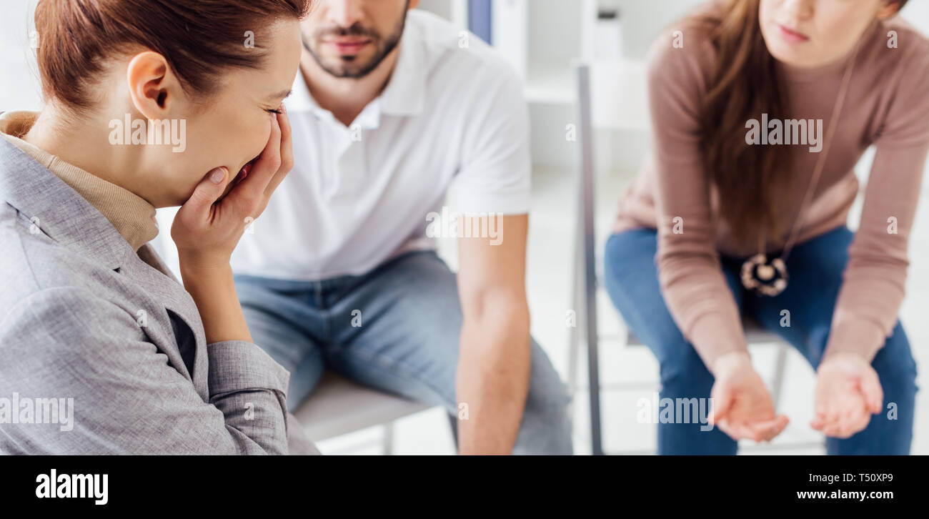 panoramic shot of upset woman crying during group therapy session Stock
