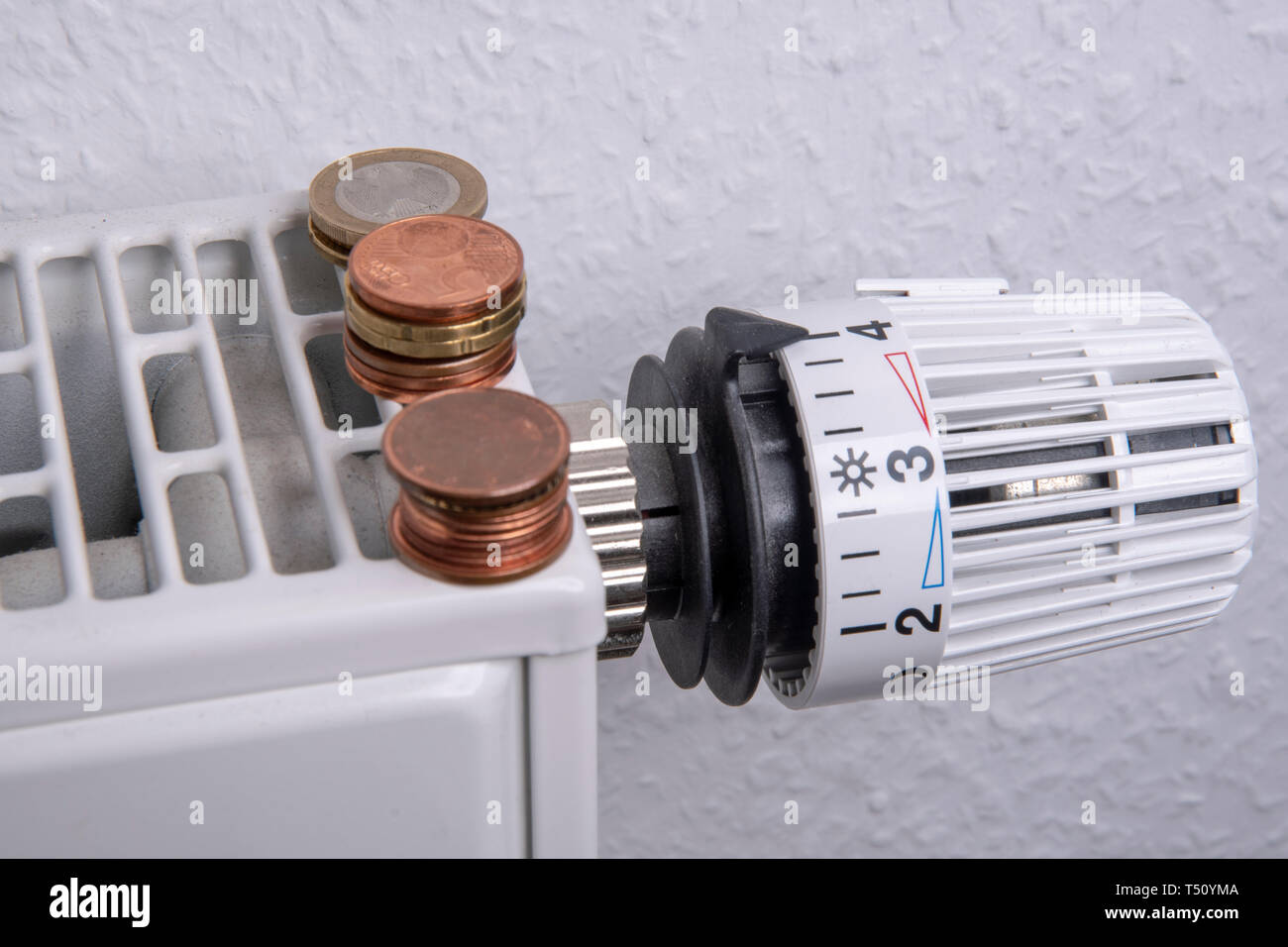 Radiator with Euro coins and thermostat Stock Photo - Alamy
