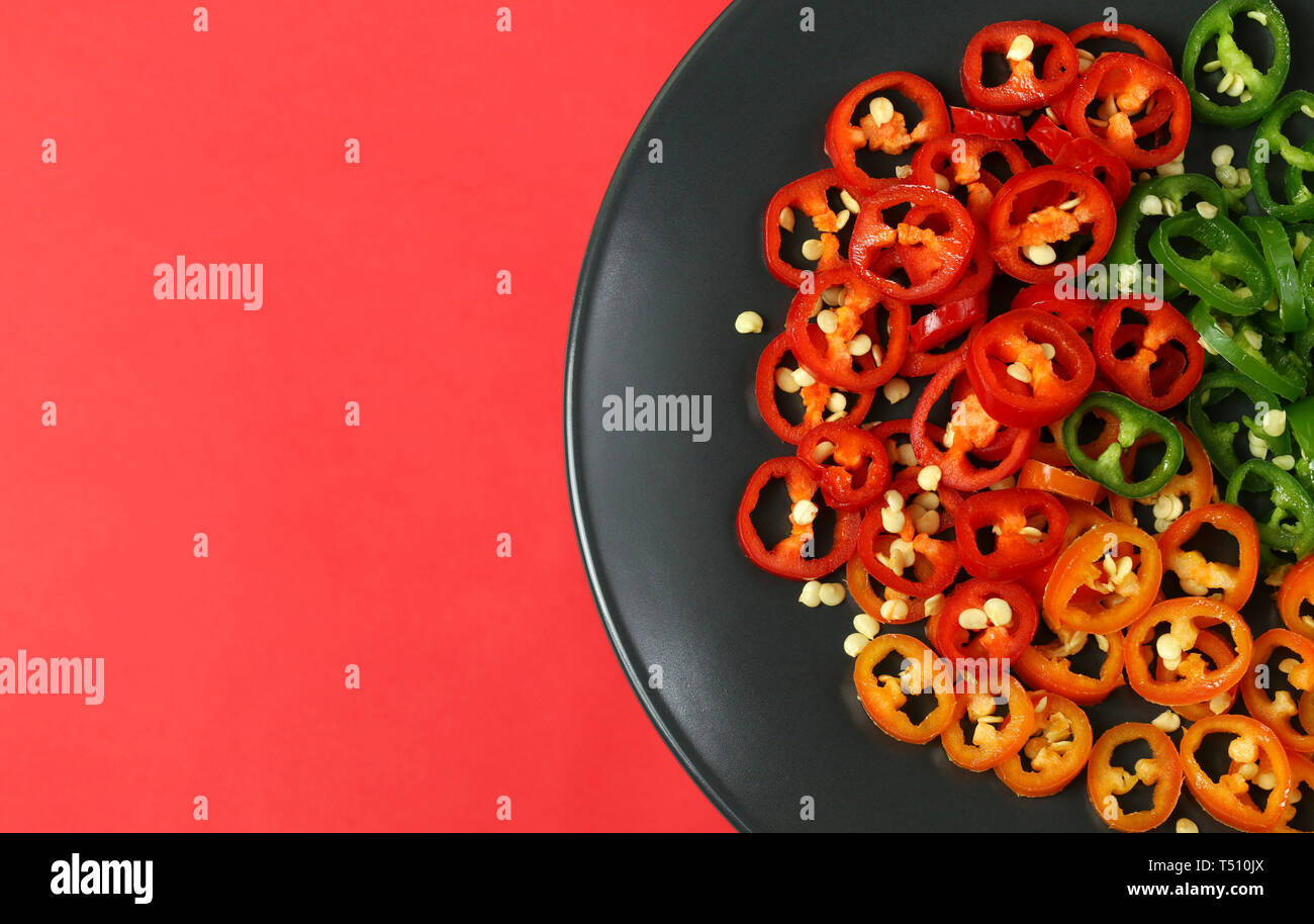 Chopped red, green and orange chili peppers. Directly above Stock Photo