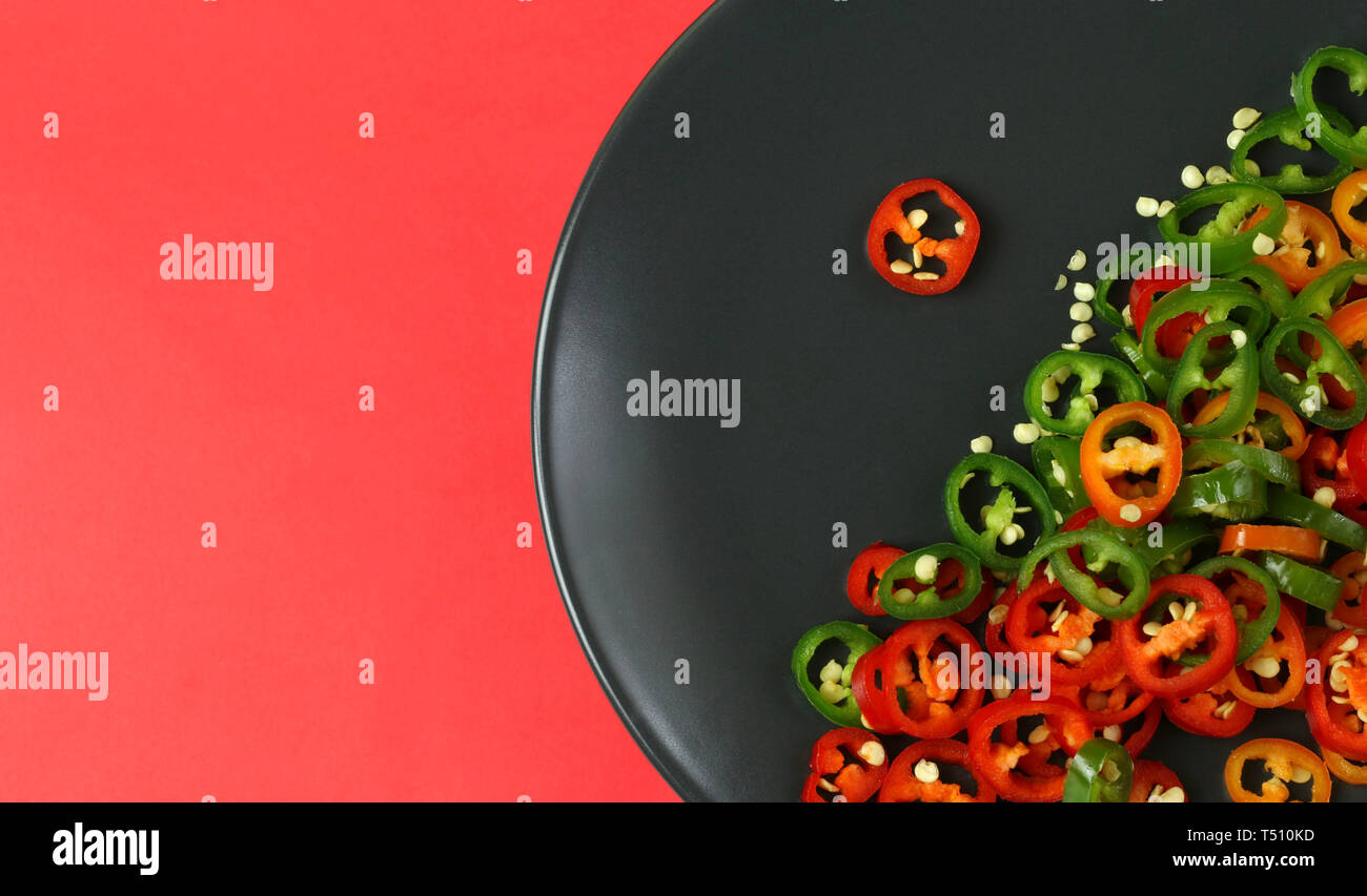 Chopped red, green and orange chili peppers. Directly above Stock Photo