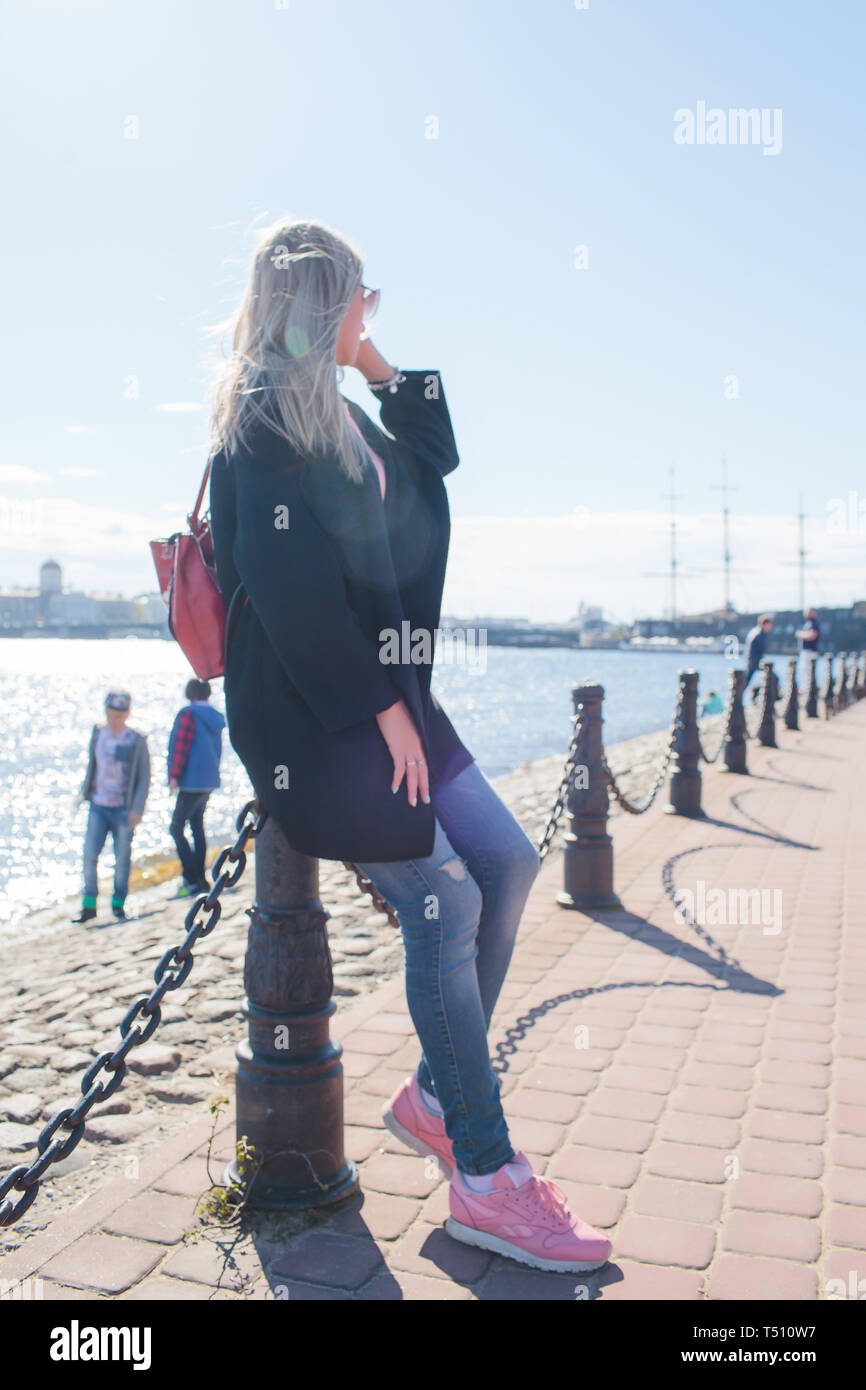 beautiful girl in a black coat walking in the city Stock Photo - Alamy