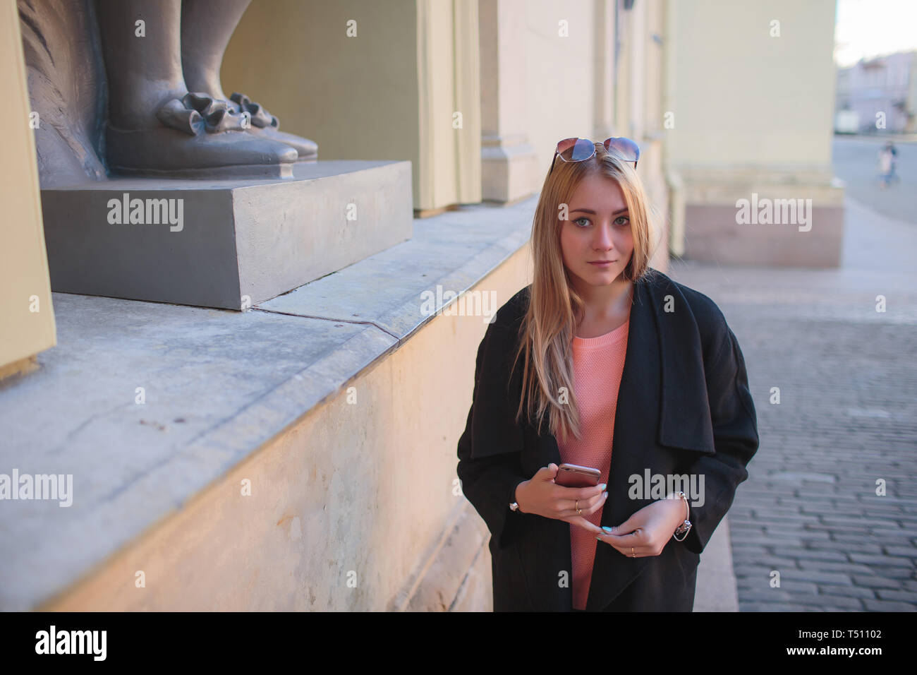 beautiful girl in a black coat walking in the city Stock Photo - Alamy