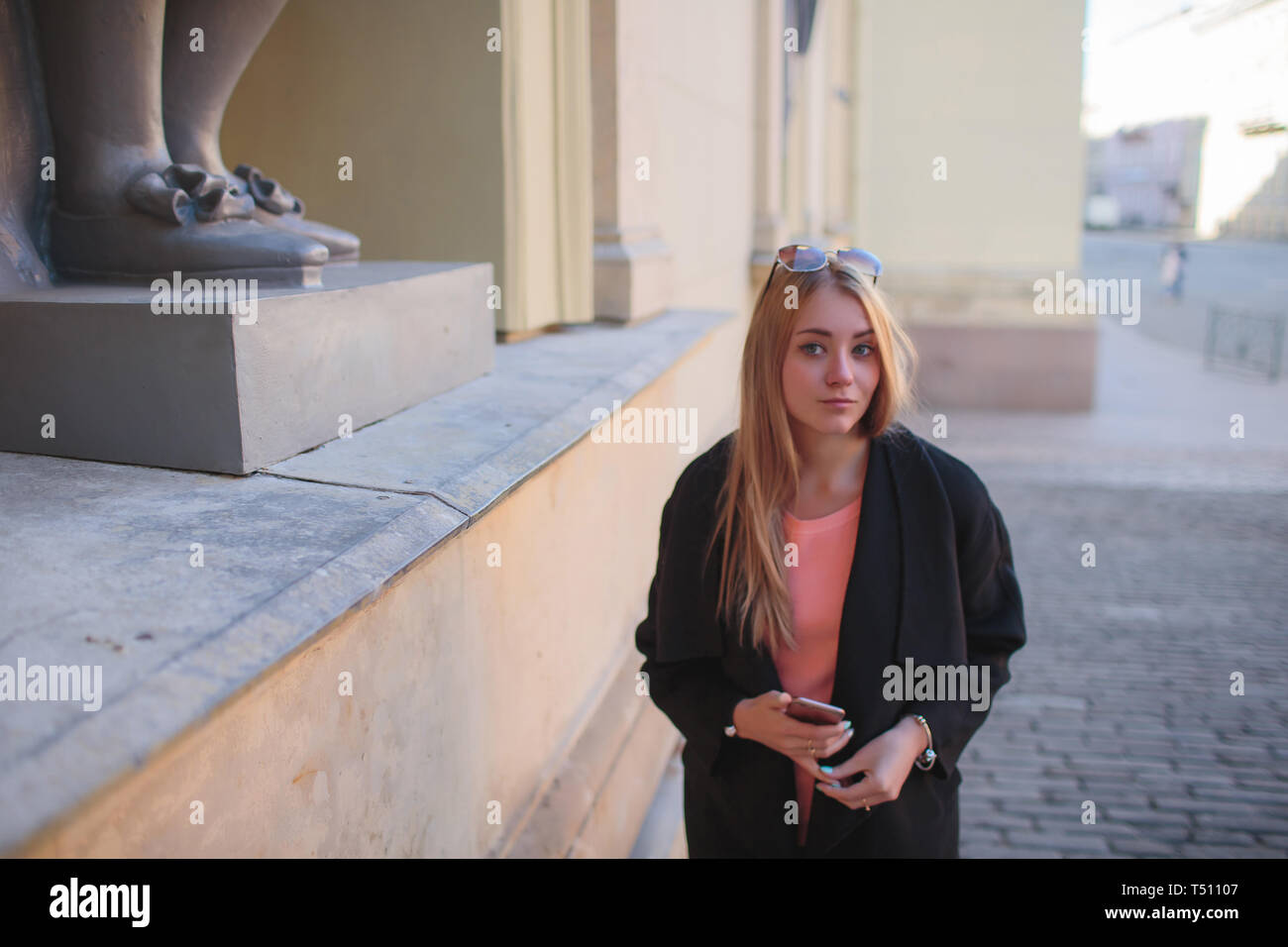 beautiful girl in a black coat walking in the city Stock Photo - Alamy