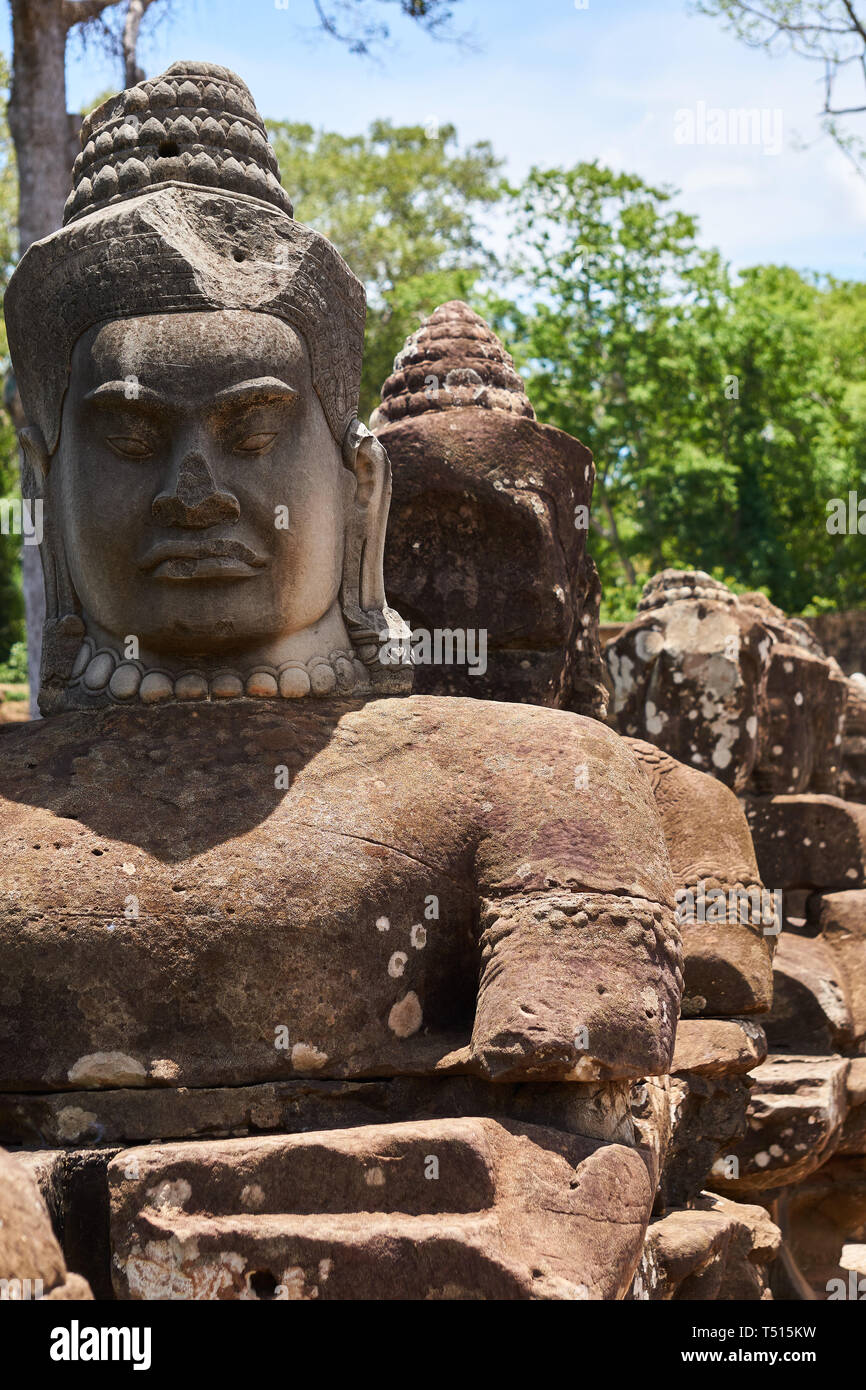 Faces of sandstone deva statues at the south gate of Angkor Thom in the ...