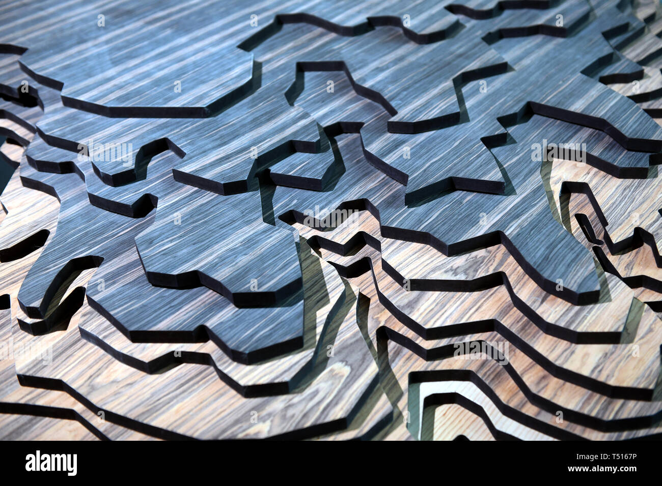 Layers of carved wood for terrain imitation model, viewed in full frame, close-up from high angle. Blue and natural wood colors Stock Photo