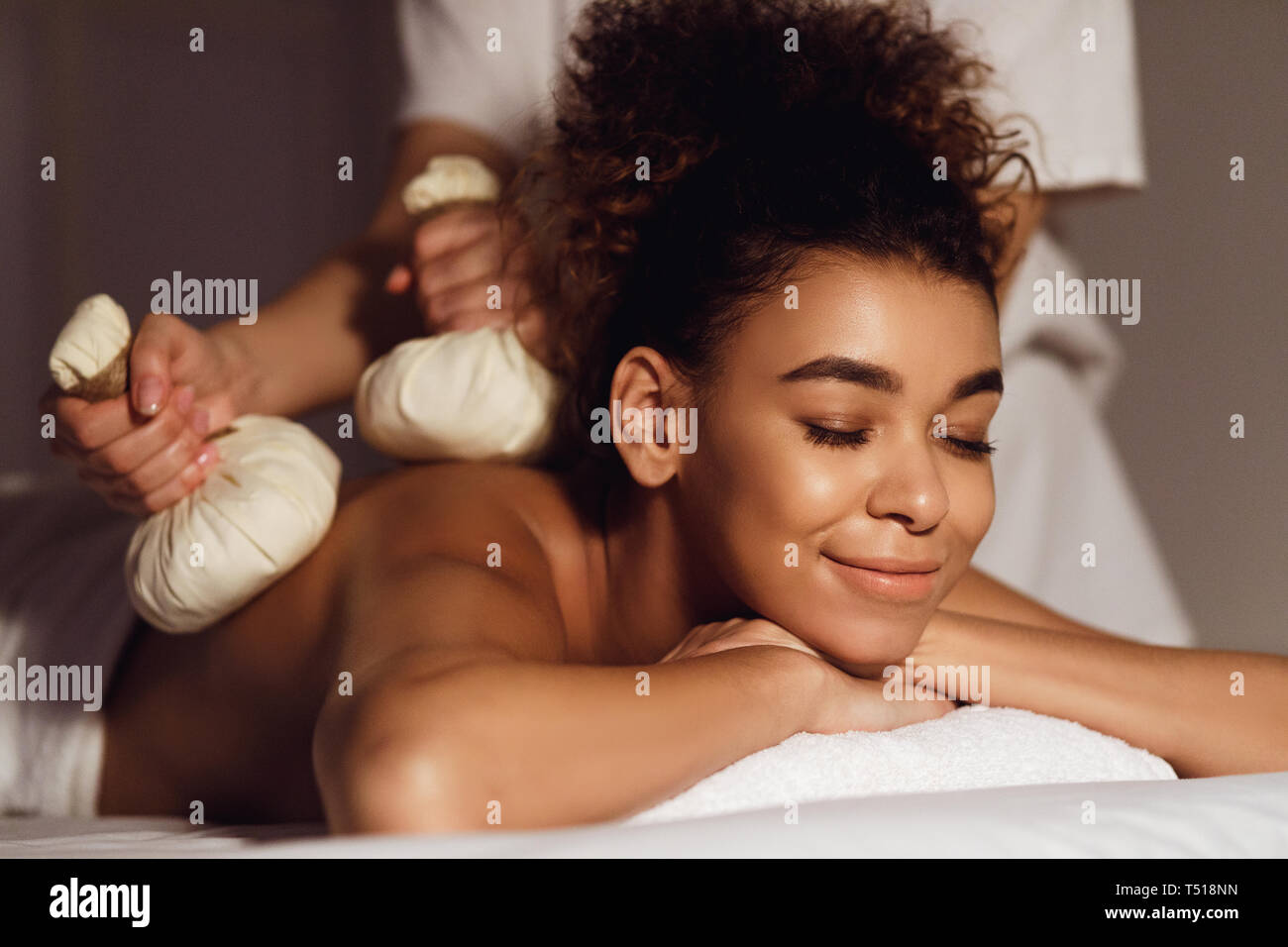 Body care. Spa body massage with hot herbal balls Stock Photo