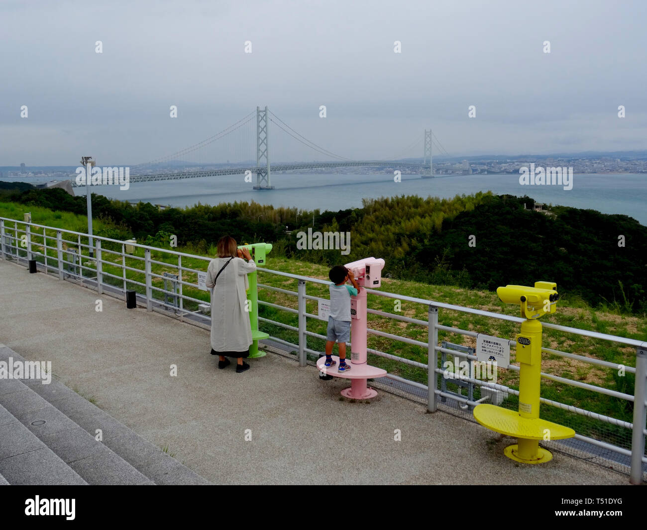 Awaji, Hyogo, Japan - 17th September 2018 : View on the Akashi Kaikyō Bridge and some toursit looking through the binoculars from the Awaji Service Ar Stock Photo