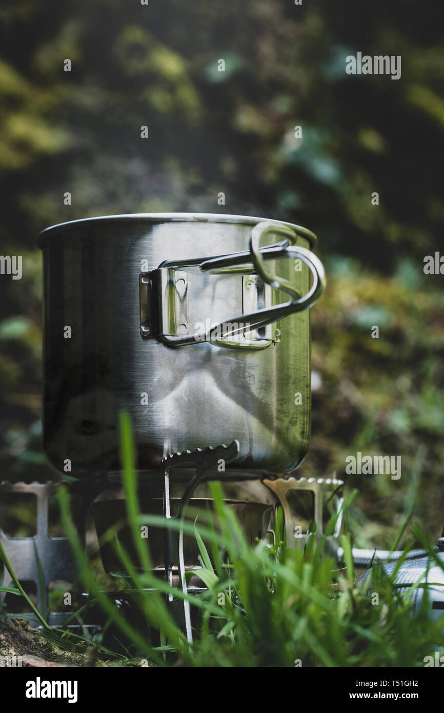 Stainless steel camp mug on a gas stove Stock Photo Alamy