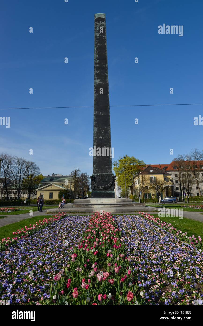 Obelisk with flower bed in front of houses roundabout, Karolinenplatz, Munich, Bavaria, Germany Stock Photo