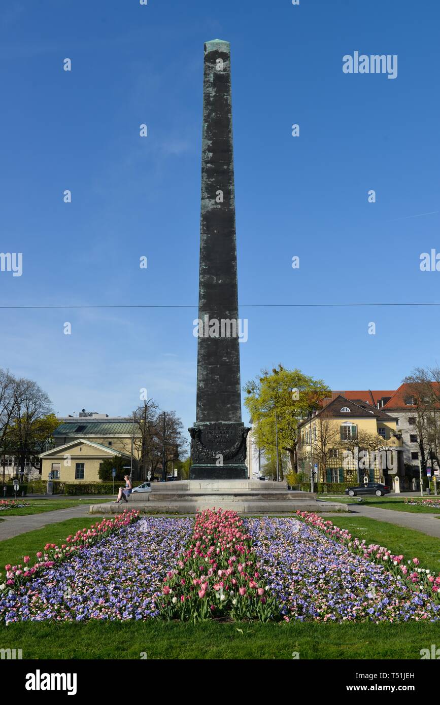 Obelisk with flower bed in front of houses roundabout, Karolinenplatz, Munich, Bavaria, Germany Stock Photo