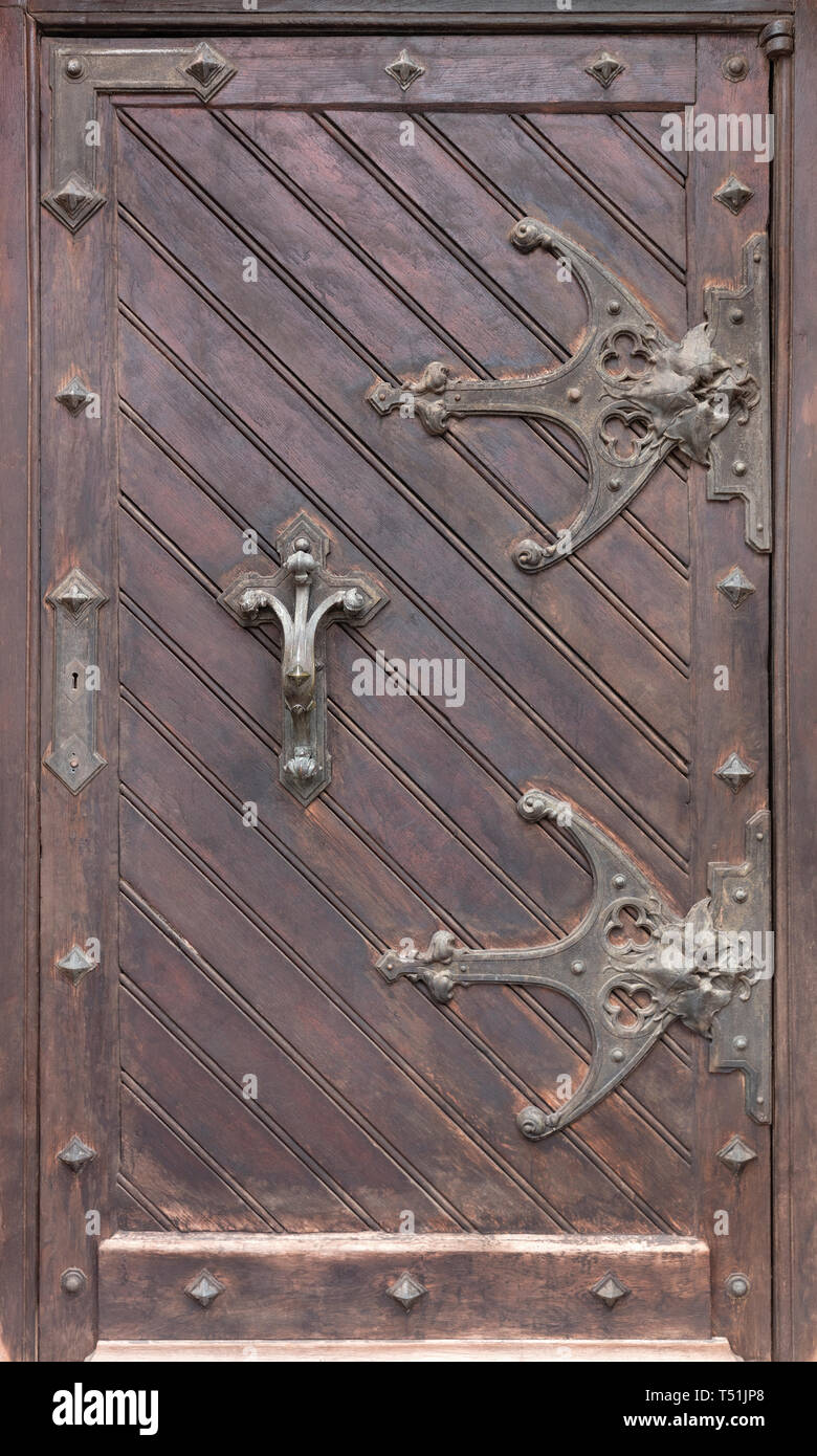 Ancient antique wooden doors with wrought iron loops, massive