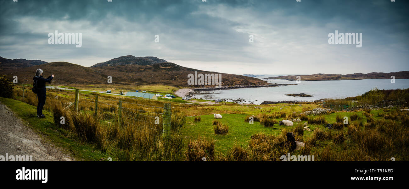 Mature female capturing the landscape of Altandhu, Summer Isles, west coast of Scotland. Stock Photo