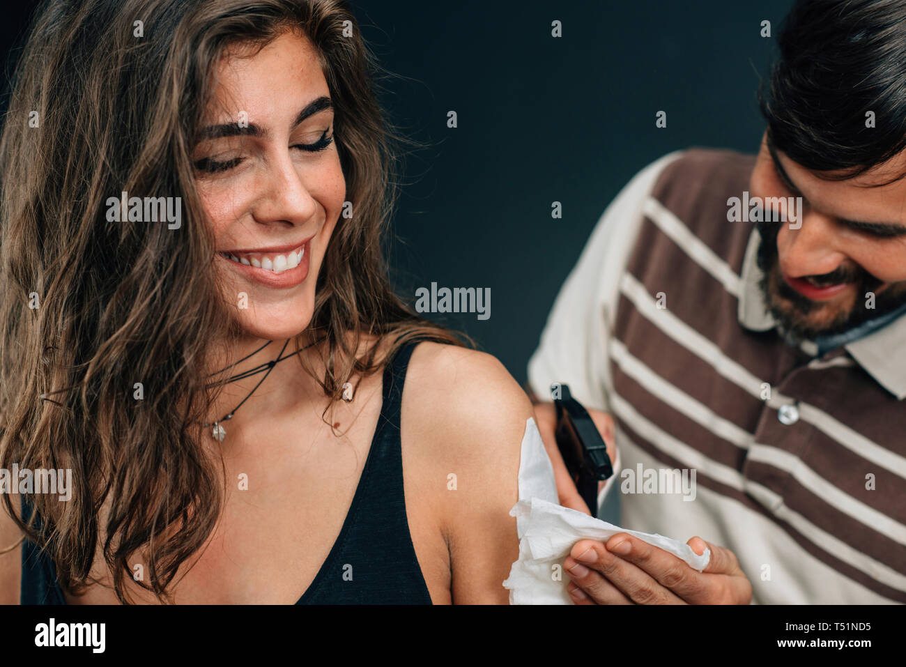 MODEL RELEASED. Temporary tattoo. Professional make-up artist applying a temporary tattoo sticker to a model's arm. Stock Photo